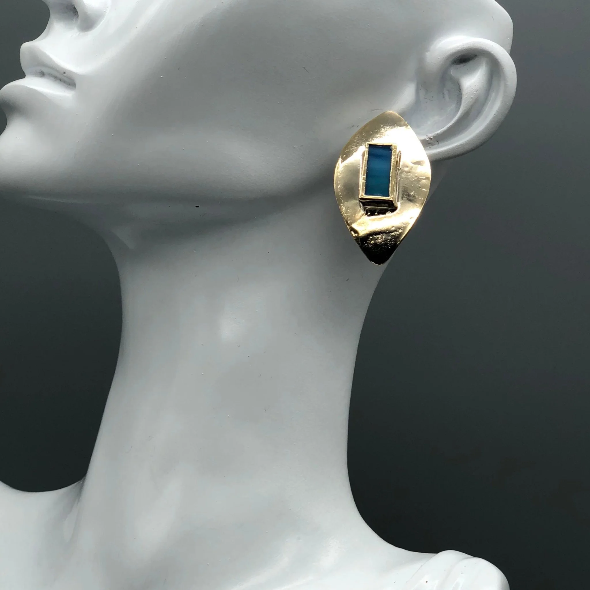 Anni Luce gold-toned earrings with rectangular blue glass insert worn on model, contemporary jewelry Crepundia Gioielli Bologna
Orecchini Anni Luce in metallo dorato con inserto rettangolare in vetro blu indossati, gioielli contemporanei Crepundia Gi