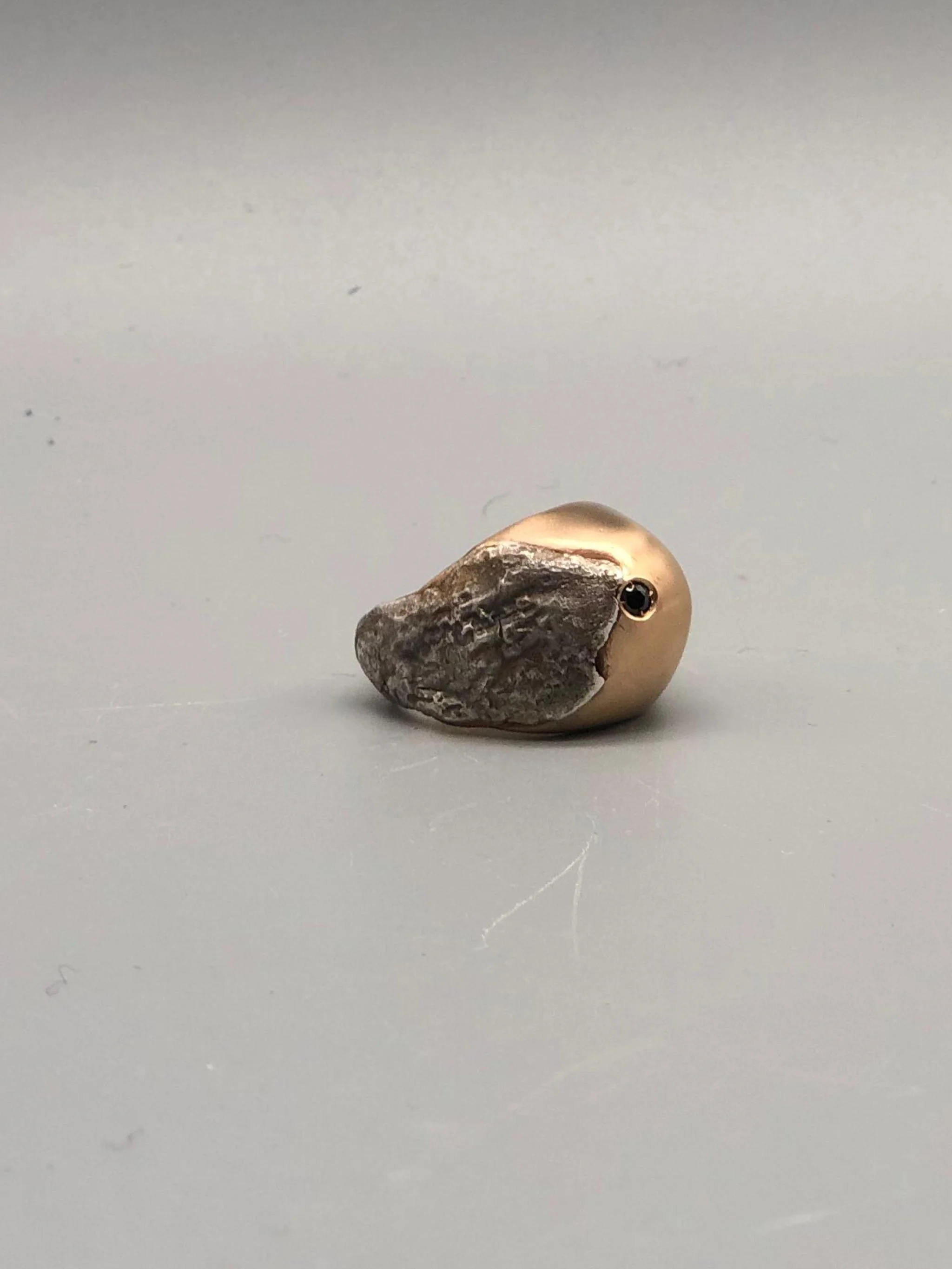 Padma Hill ring in rose bronze with raw silver application, garnet and black zircon. Sculptural contemporary handmade ring available at Crepundia Gioielli Bologna.