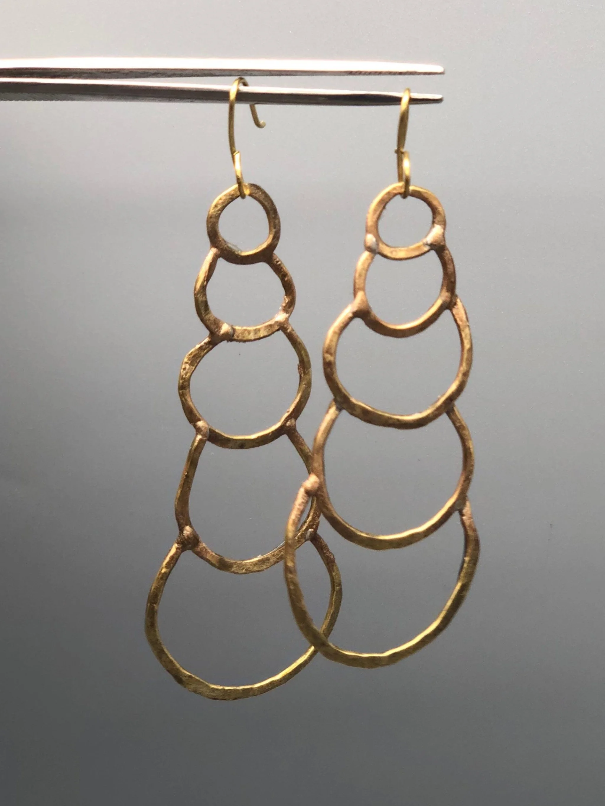Orecchini Outline Drops di Claudia Cuzzeri in ottone opaco con forme circolari irregolari.