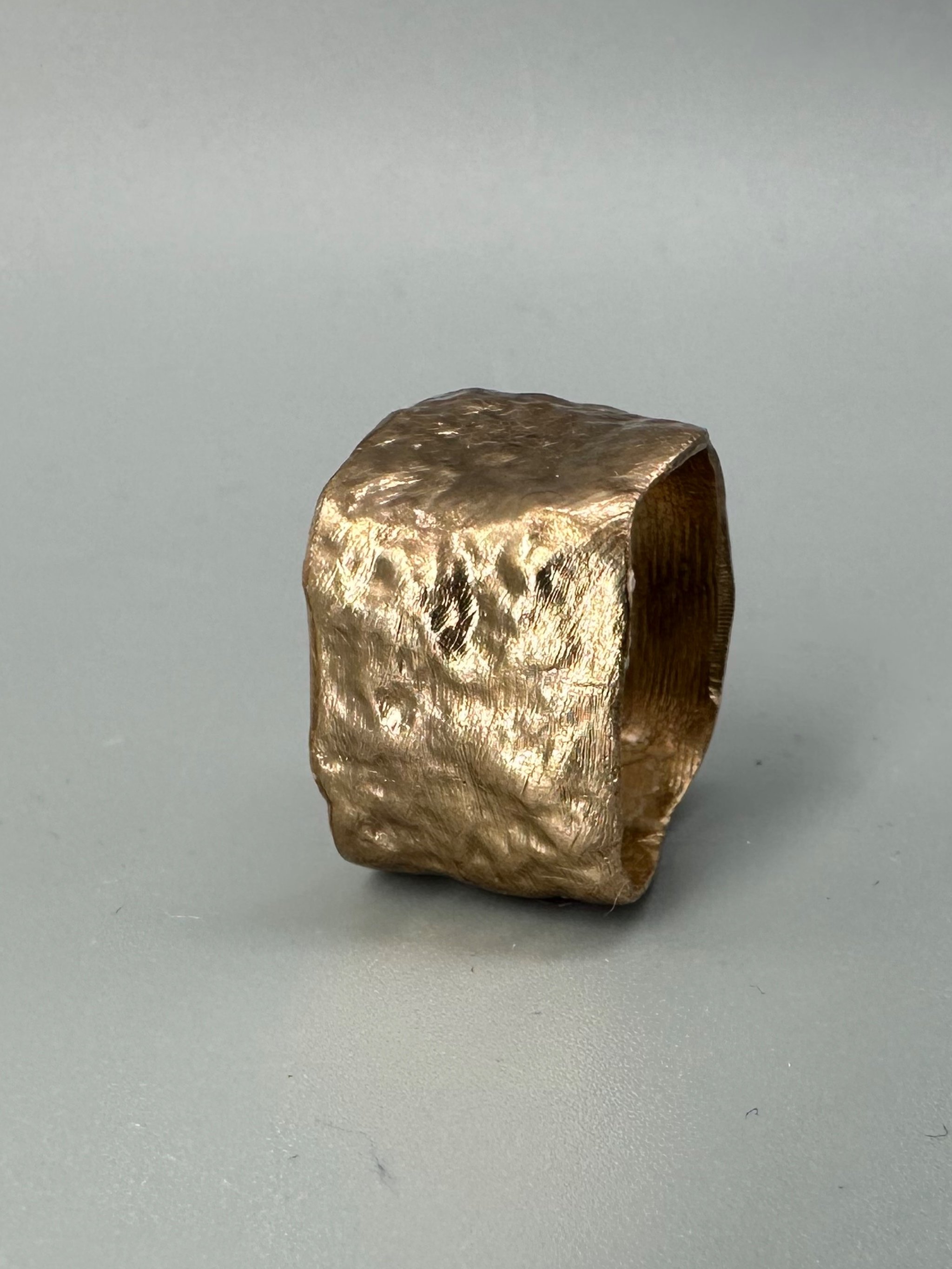 Anello Fascia Longobarda di CōDICEDS in bronzo bocciardato, dalla forma ampia e irregolare.  Longobarda wide bronze ring by CōDICEDS, with a hammered surface and irregular shape.