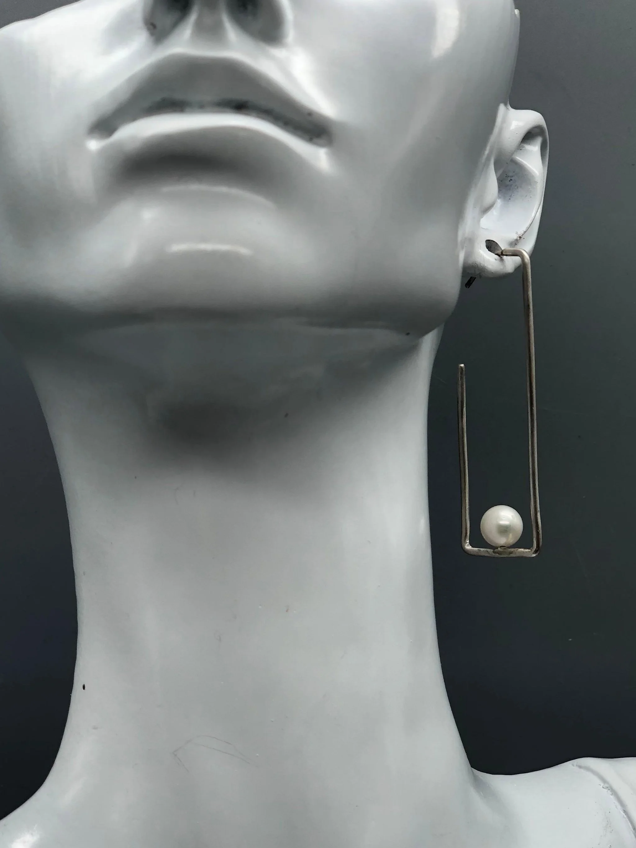 Crepundia Agadir earrings in silver with pearls, featuring an open, asymmetrical geometric design.