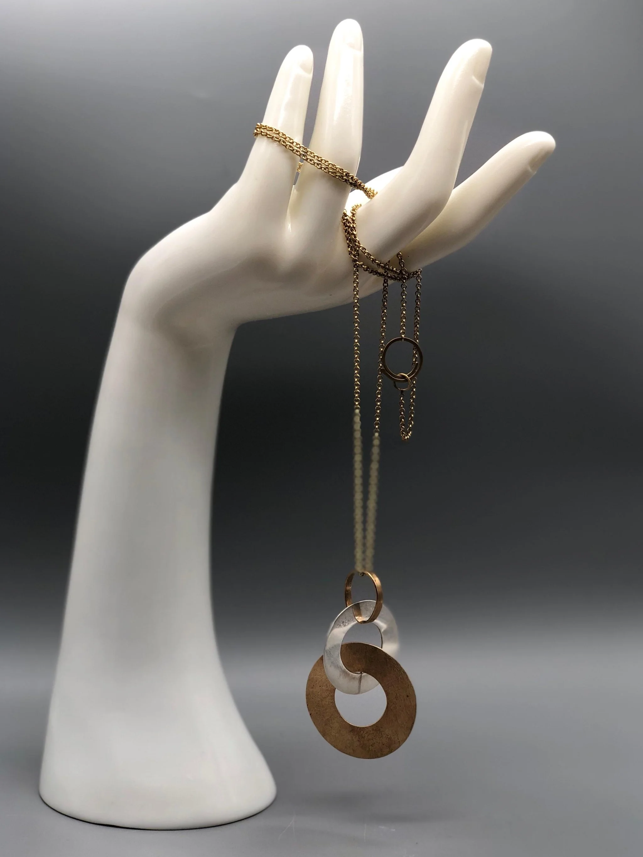 Pendente Dischi Intrecciati di Padma per Crepundia Gioielli Bologna in argento e similoro con catena in ottone
