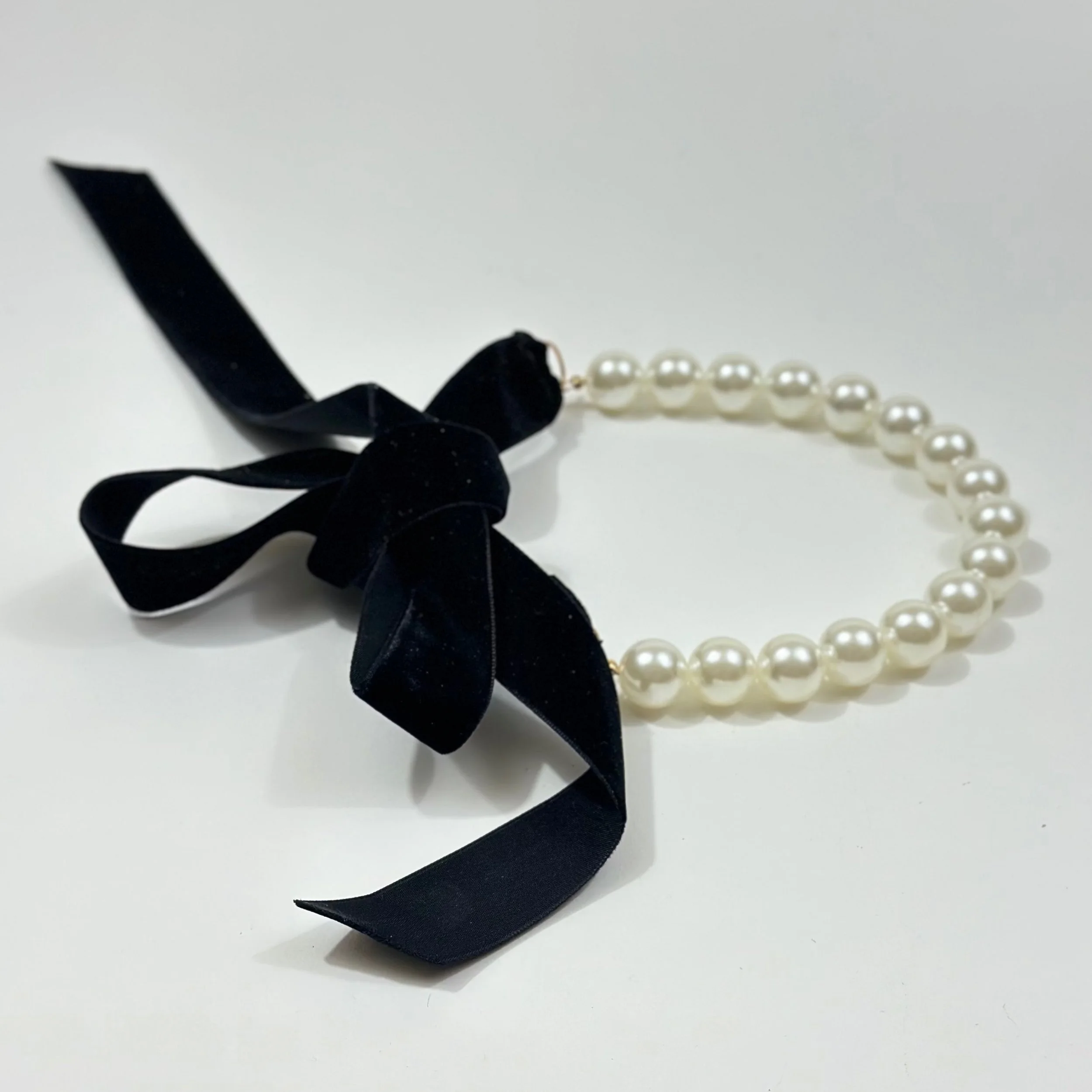 Collana Pearl Drama con perle sintetiche e fiocco nero, Crepundia Gioielli.