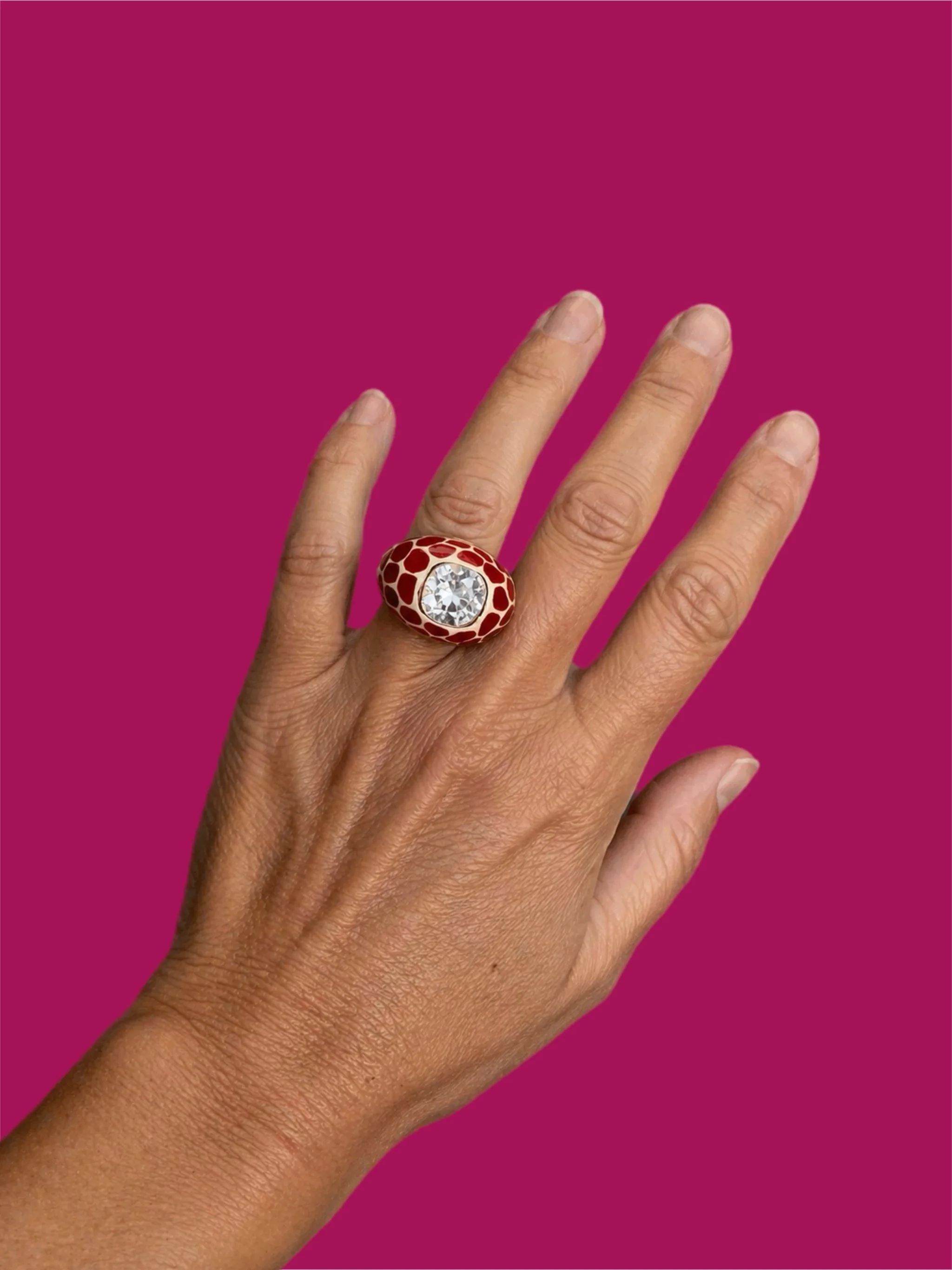 Kenneth Jay Lane ring worn on hand, gold-tone with red enameland central crystal, costume jewelry, Crepundia Gioielli Bologna
Anello Kenneth Jay Lane indossato sulla mano, dorato con smalto rosso e cristallo centrale, costume jewelry, Crepundia Gioie