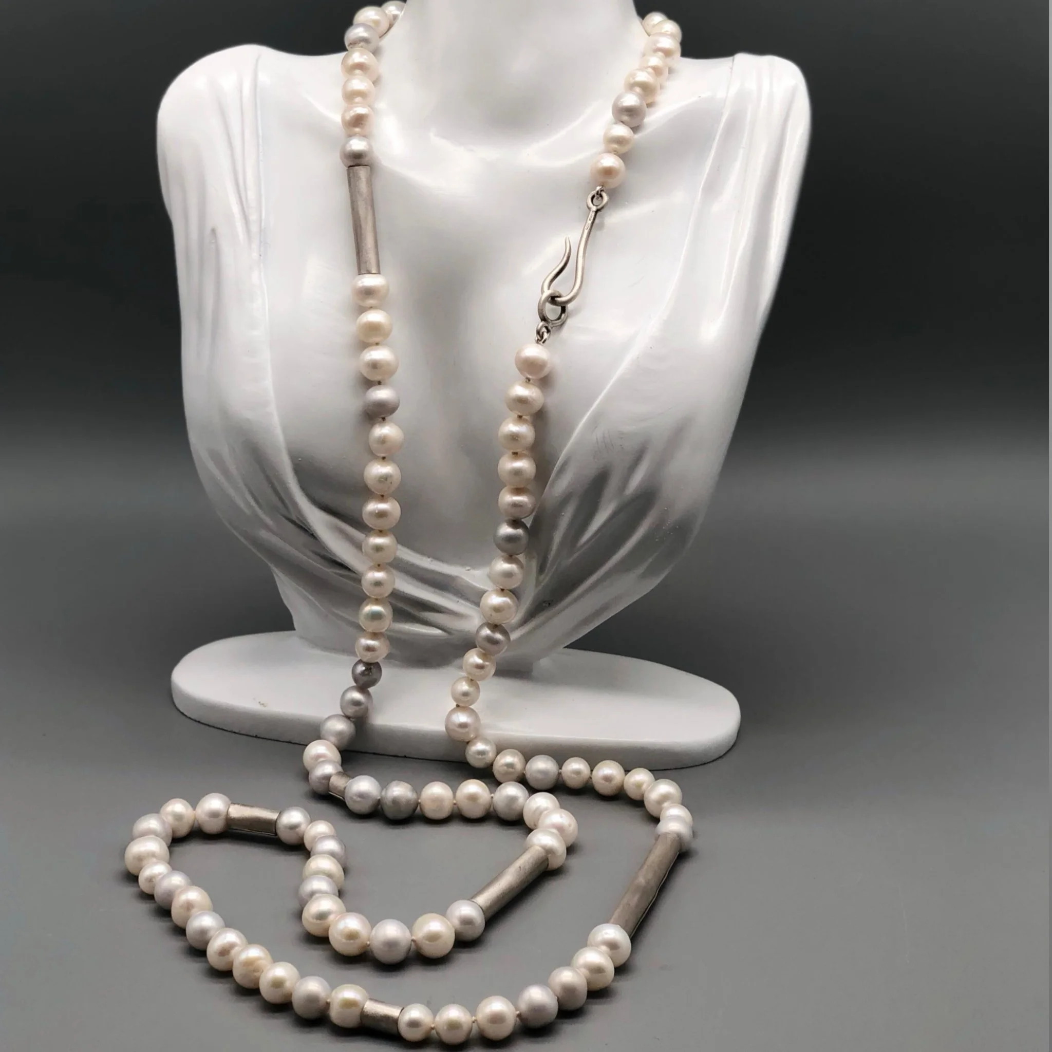 Collana di perle bianche e grigie con elementi in argento opaco, composizione fluida e modulare.
Crepundia Gioielli — Crepundia Bologna.
White and grey pearl necklace with matte silver elements, fluid and modular composition.
Crepundia Jewelry — Crep