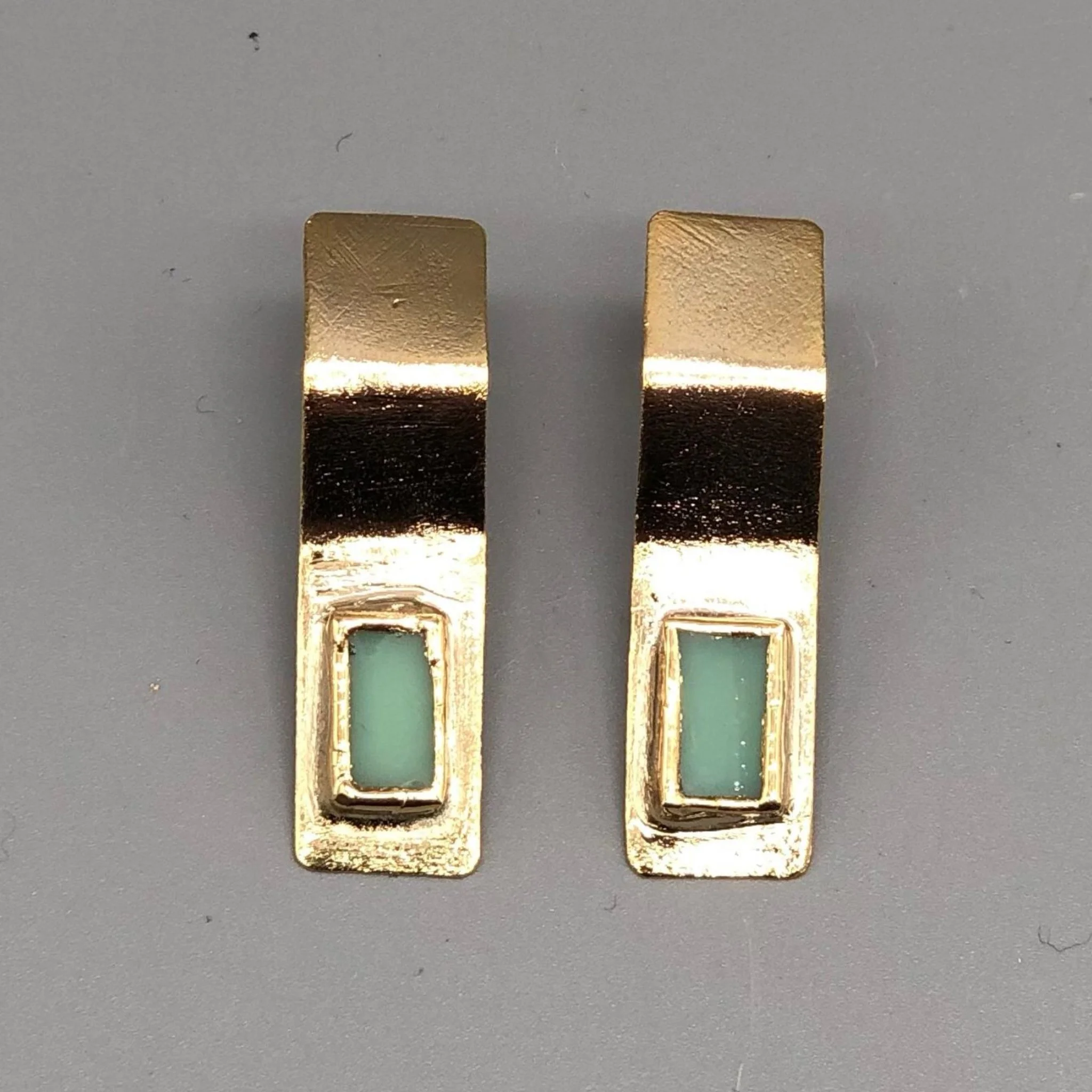 Anni Luce gold-toned earrings with rectangular green glass insert, contemporary jewelry Crepundia Gioielli Bologna
Orecchini Anni Luce in metallo dorato con inserto rettangolare in vetro verde, gioielli contemporanei Crepundia Gioielli Bologna