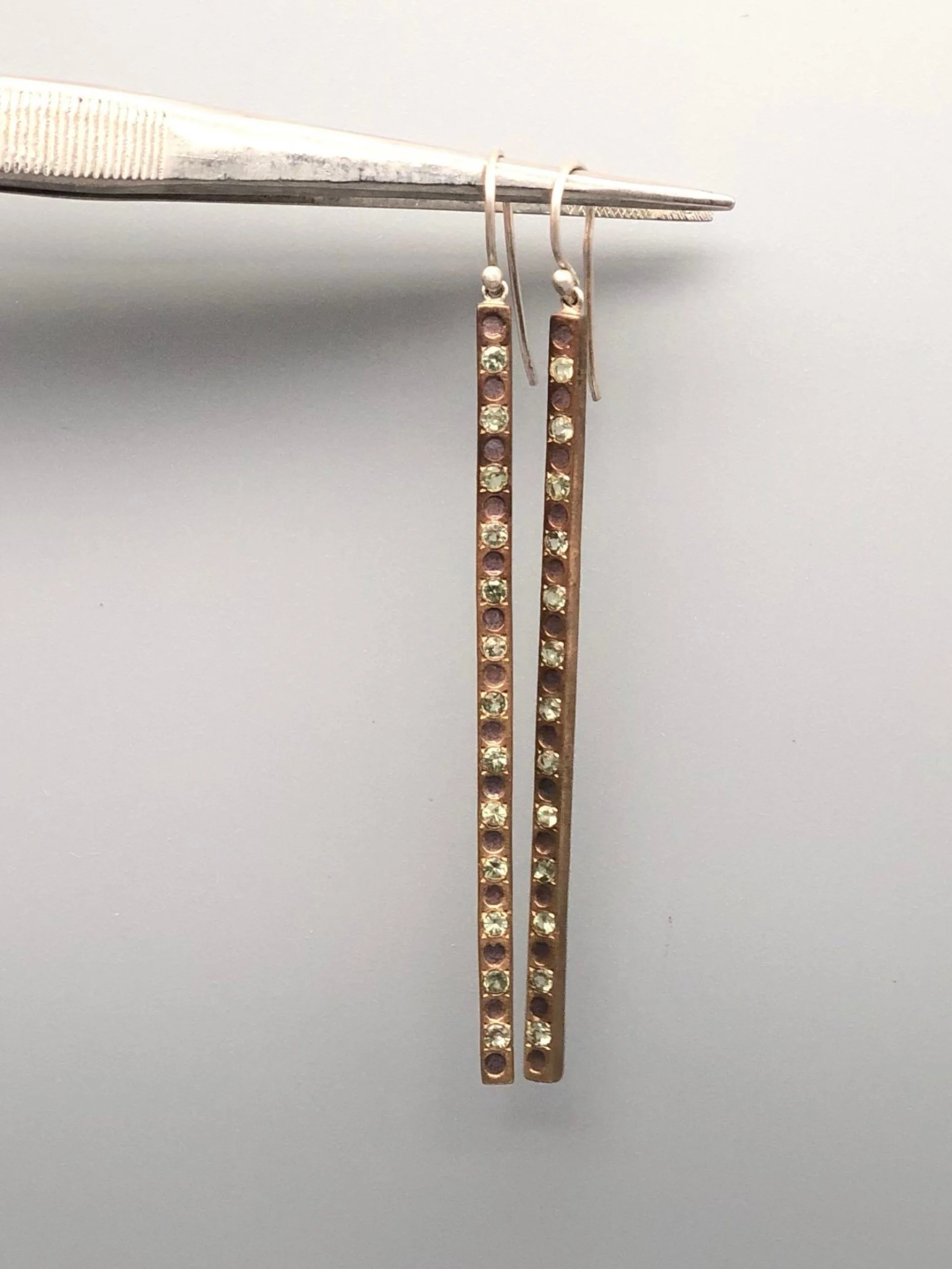 Raimondi long earrings in silver and bronze with green sapphires.