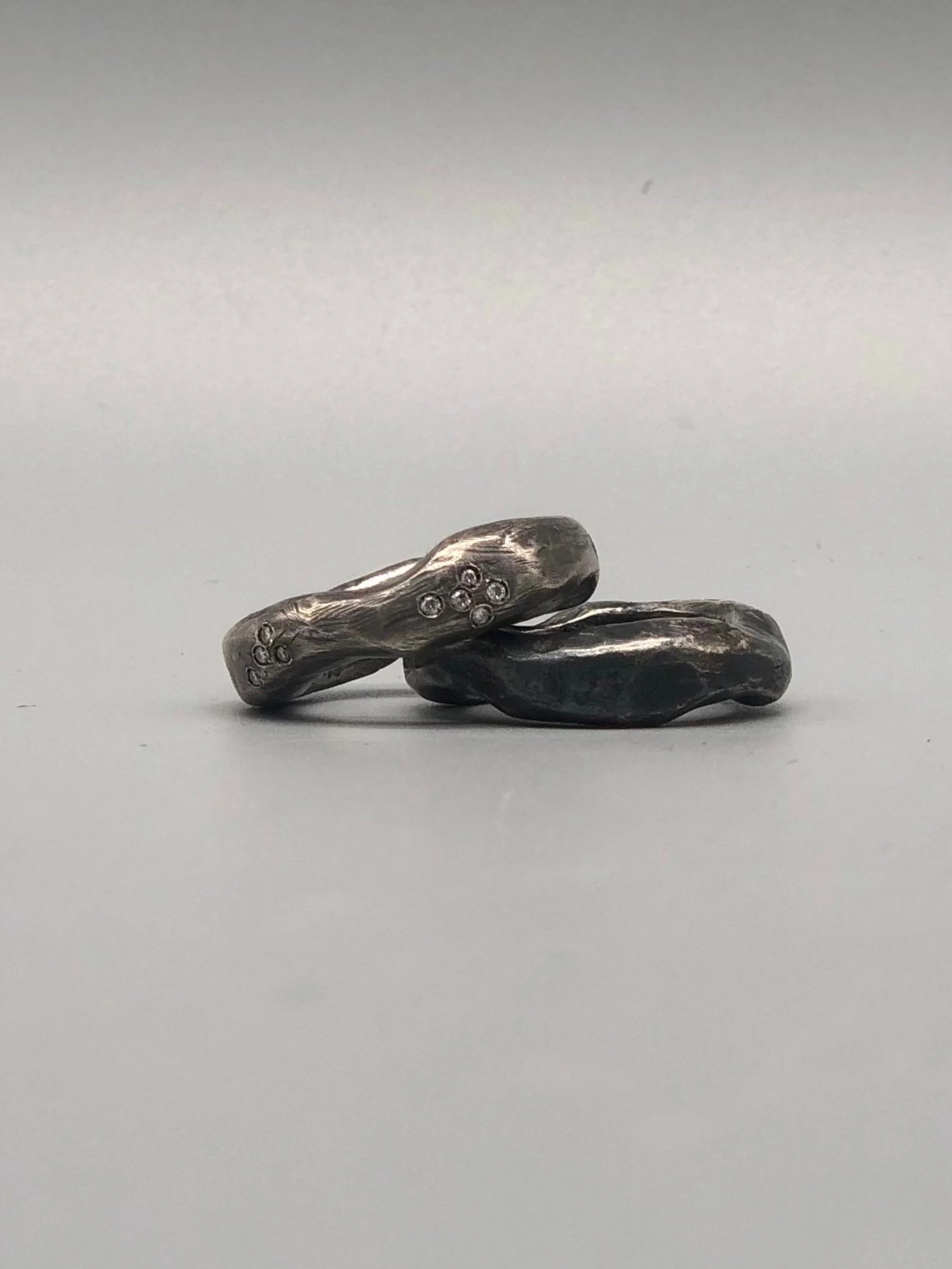 Due anelli Lingotto in argento brunito, uno con diamanti e uno senza, affiancati, Crepundia Gioielli Bologna