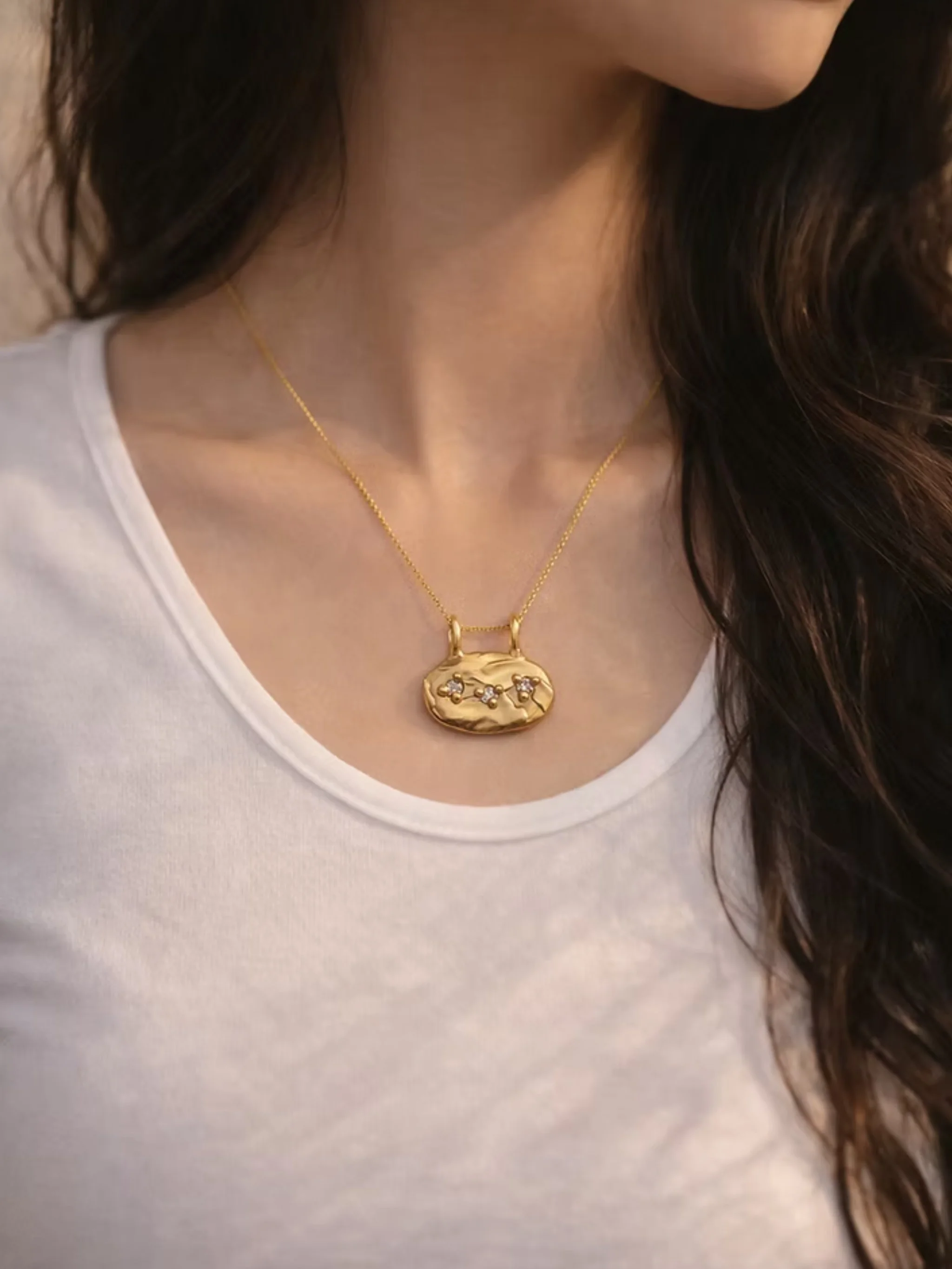 Oval bronze pendant with three zircon stones by Floret Gioielli.