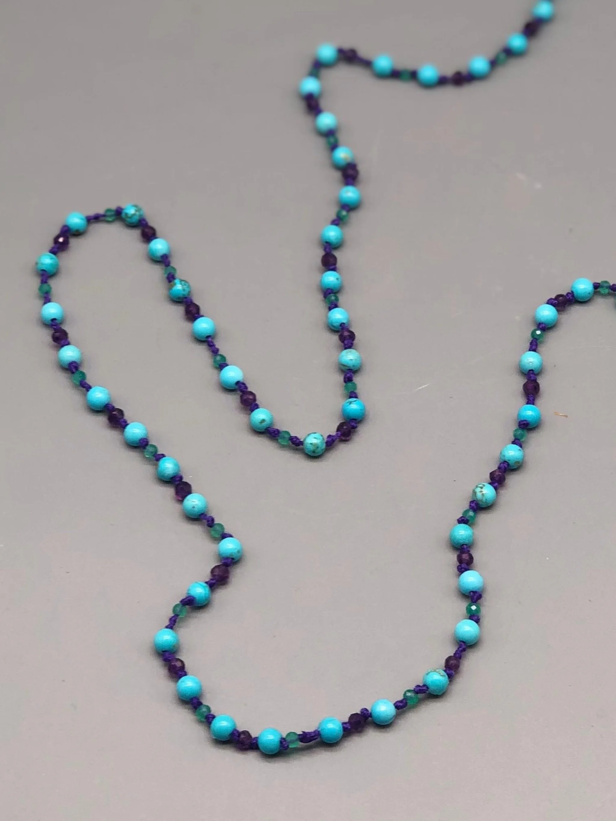 Summer necklace with turquoise, amethyst and aventurine on purple cotton cord. Crepundia Gioielli Bologna.