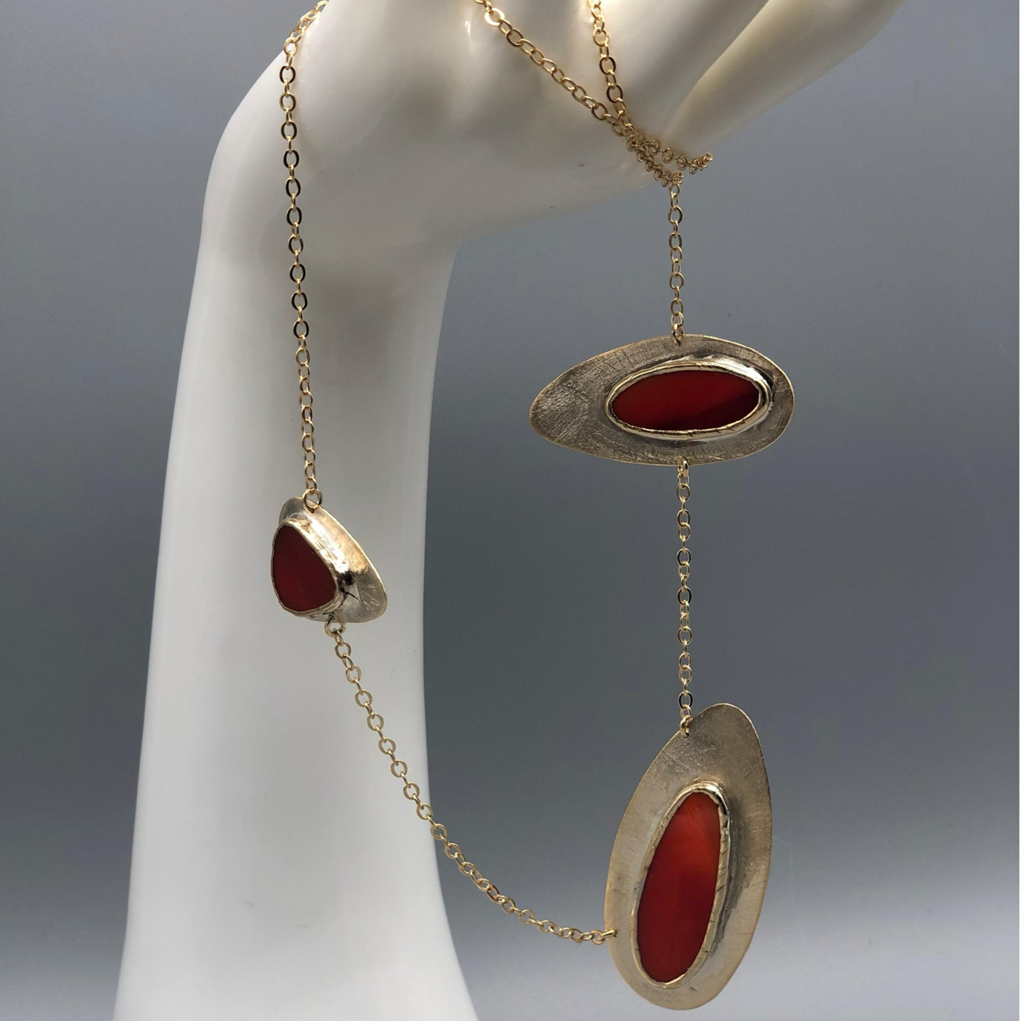 Anni Luce necklace in gold-toned metal with red glass elements, contemporary jewelry Crepundia Gioielli Bologna
Collana Anni Luce in metallo dorato con elementi in vetro rosso, gioielli contemporanei Crepundia Gioielli Bologna