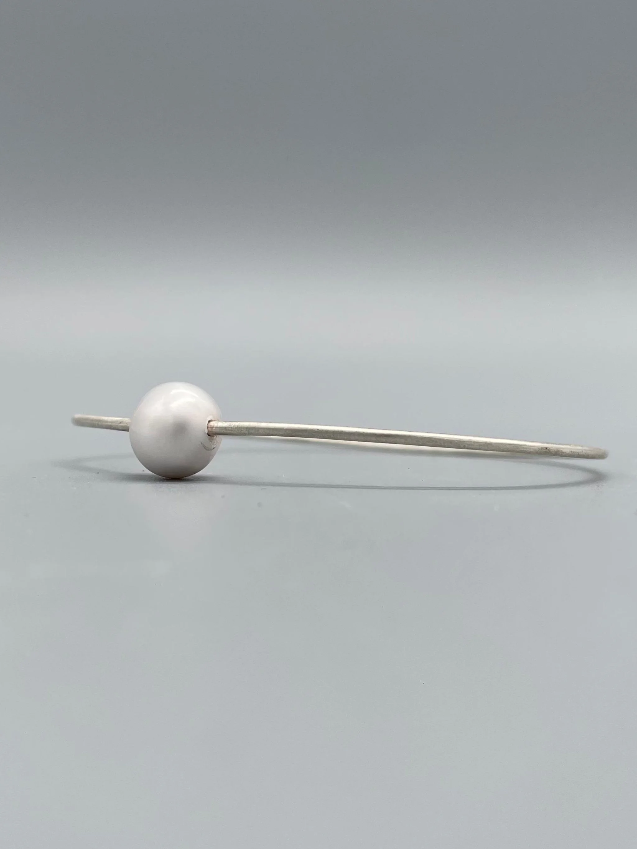 Bracciale Assuan Crepundia in argento con perla, design contemporaneo.