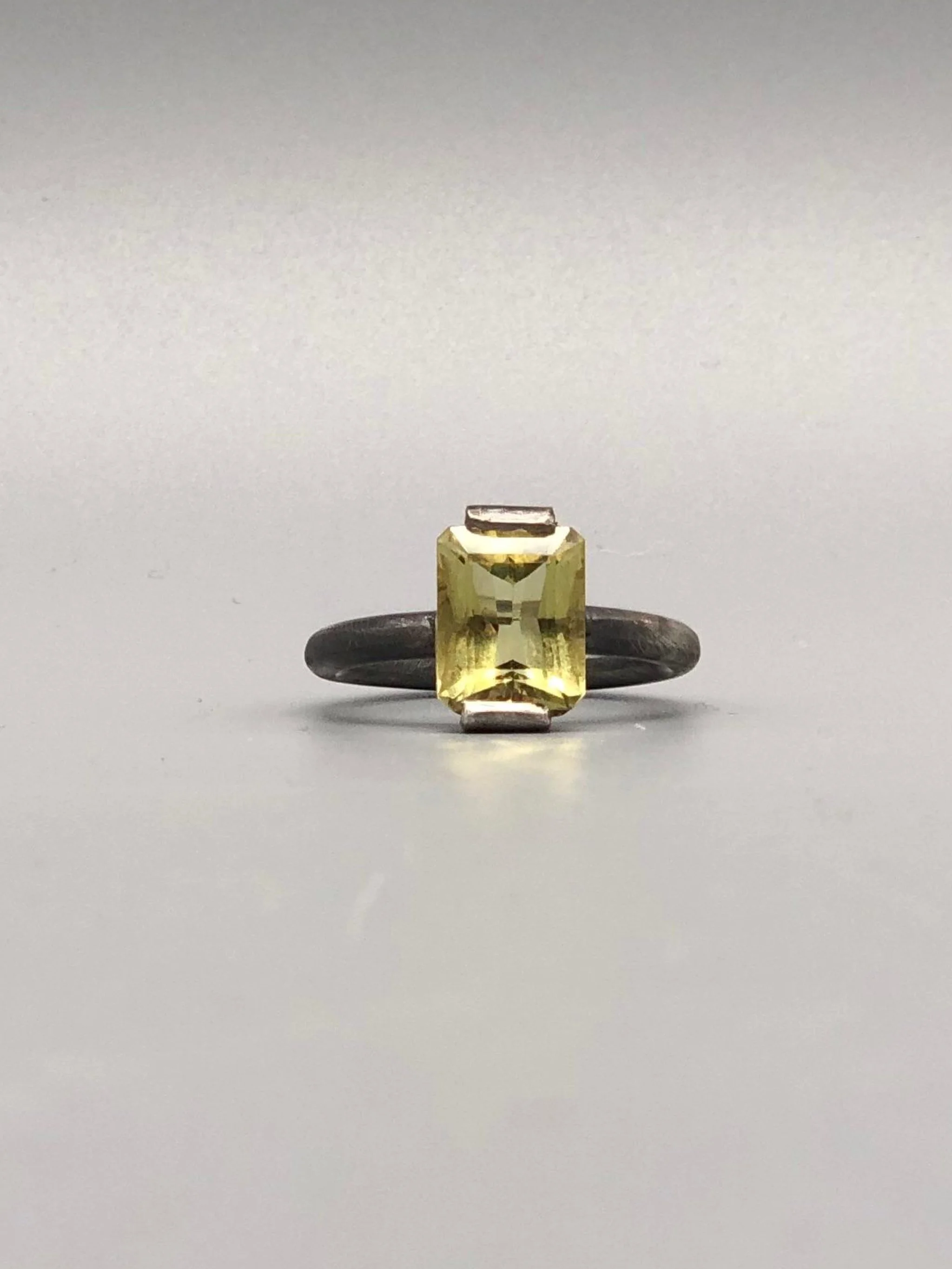Anello in argento brunito con quarzo lemon, colore pieno e geometria essenziale, un punto di luce netto nella materia.
Oxidized silver ring with lemon quartz, bold color and essential geometry, a sharp point of light within the material.