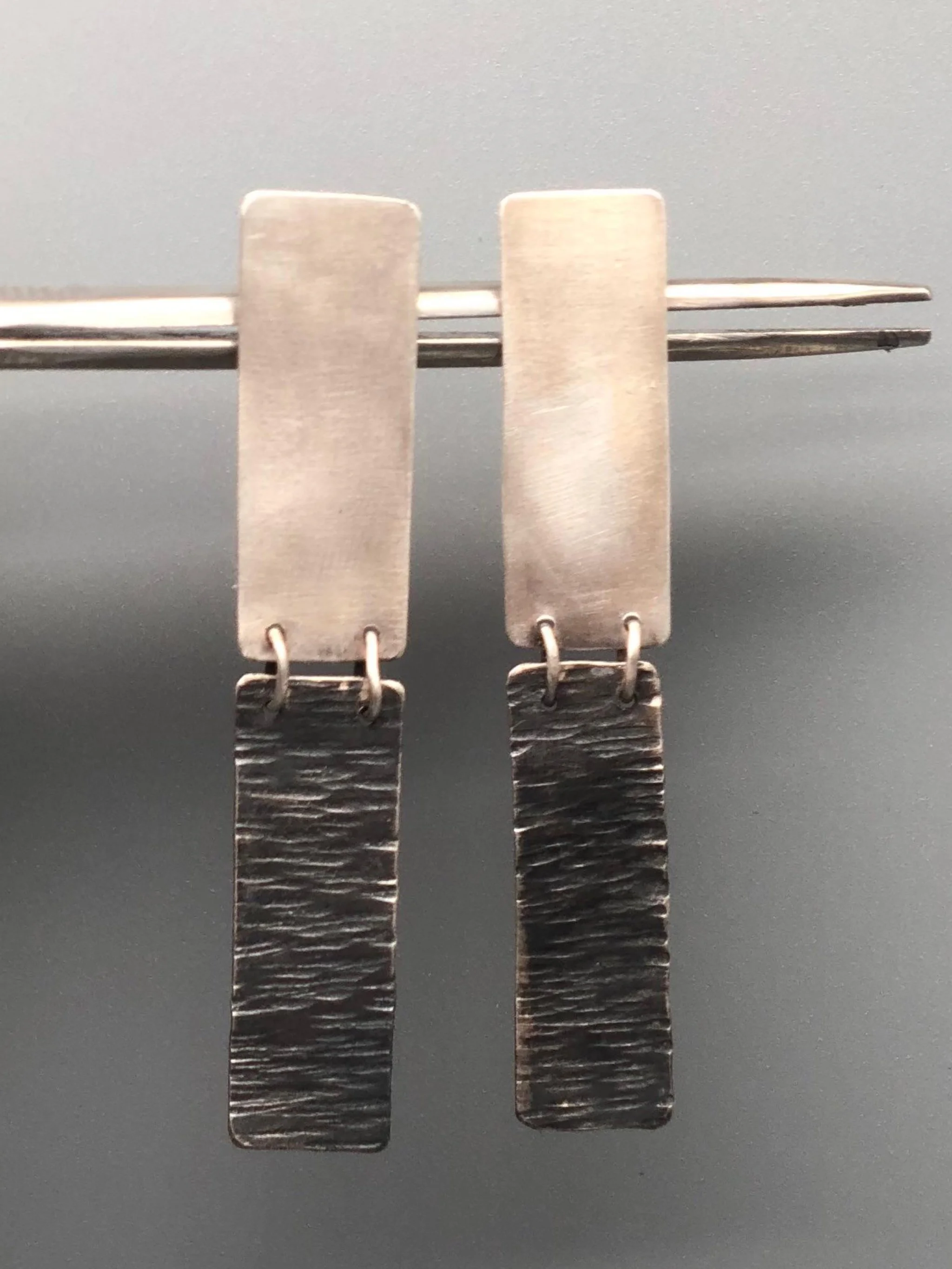 Dual earrings in matte silver and oxidized silver, Crepundia Gioielli Bologna.
