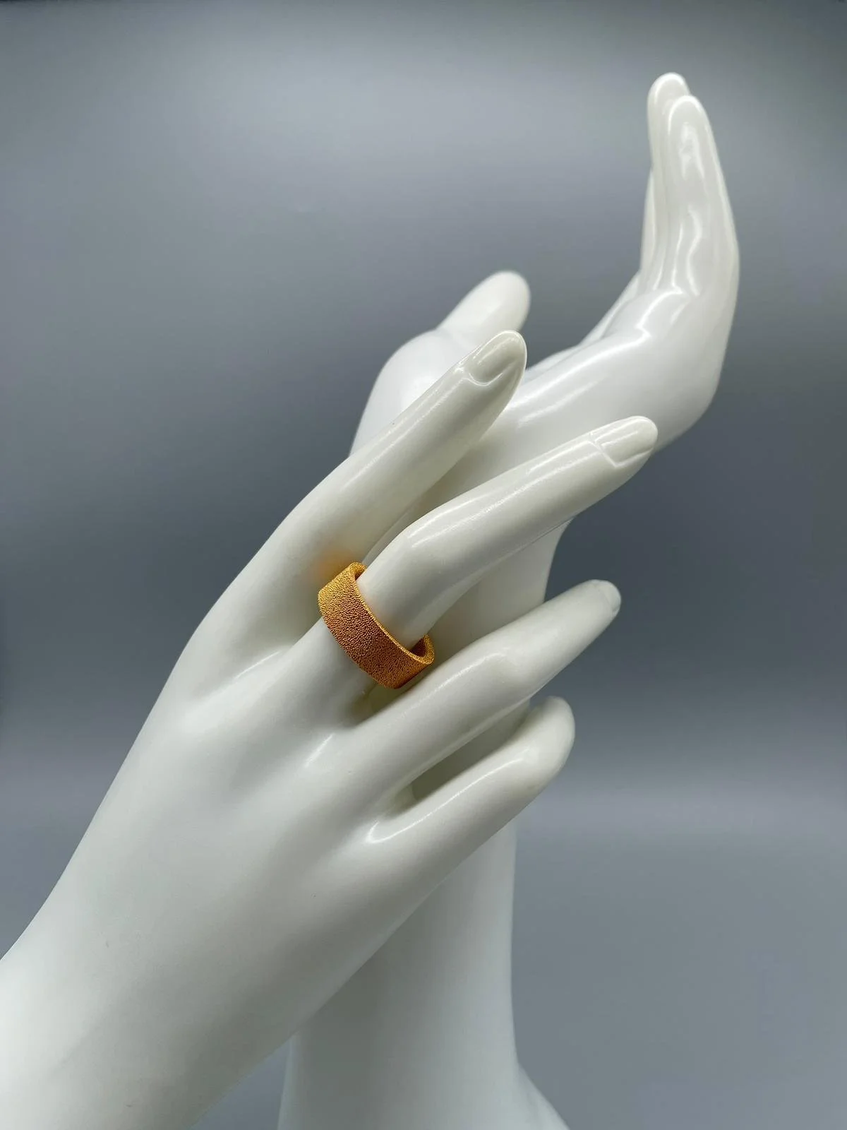 Anello in bronzo sinterizzato da recupero industriale, superfici materiche e stratificate con finitura galvanica oro, composizione modulare indossata — Francesca Valpiani, Crepundia Gioielli — Crepundia Bologna
Ring in sintered bronze from industrial