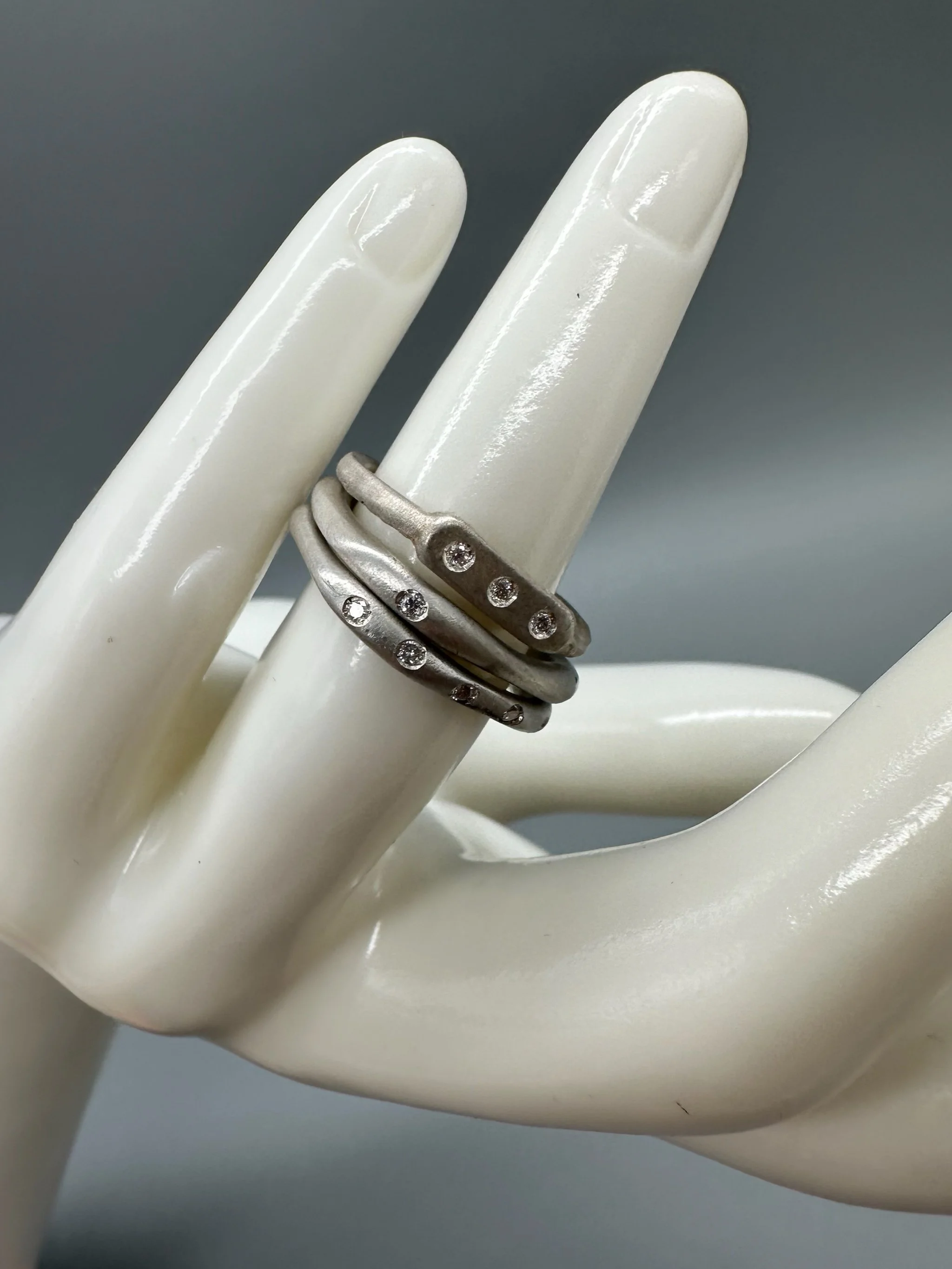 Interplay di Crepundia Gioielli, composizione di tre anelli in argento Full Wave, Wave e Flat 3, con diamanti per un totale di 0,12 ct. Interplay by Crepundia Gioielli, a set of three contemporary sil