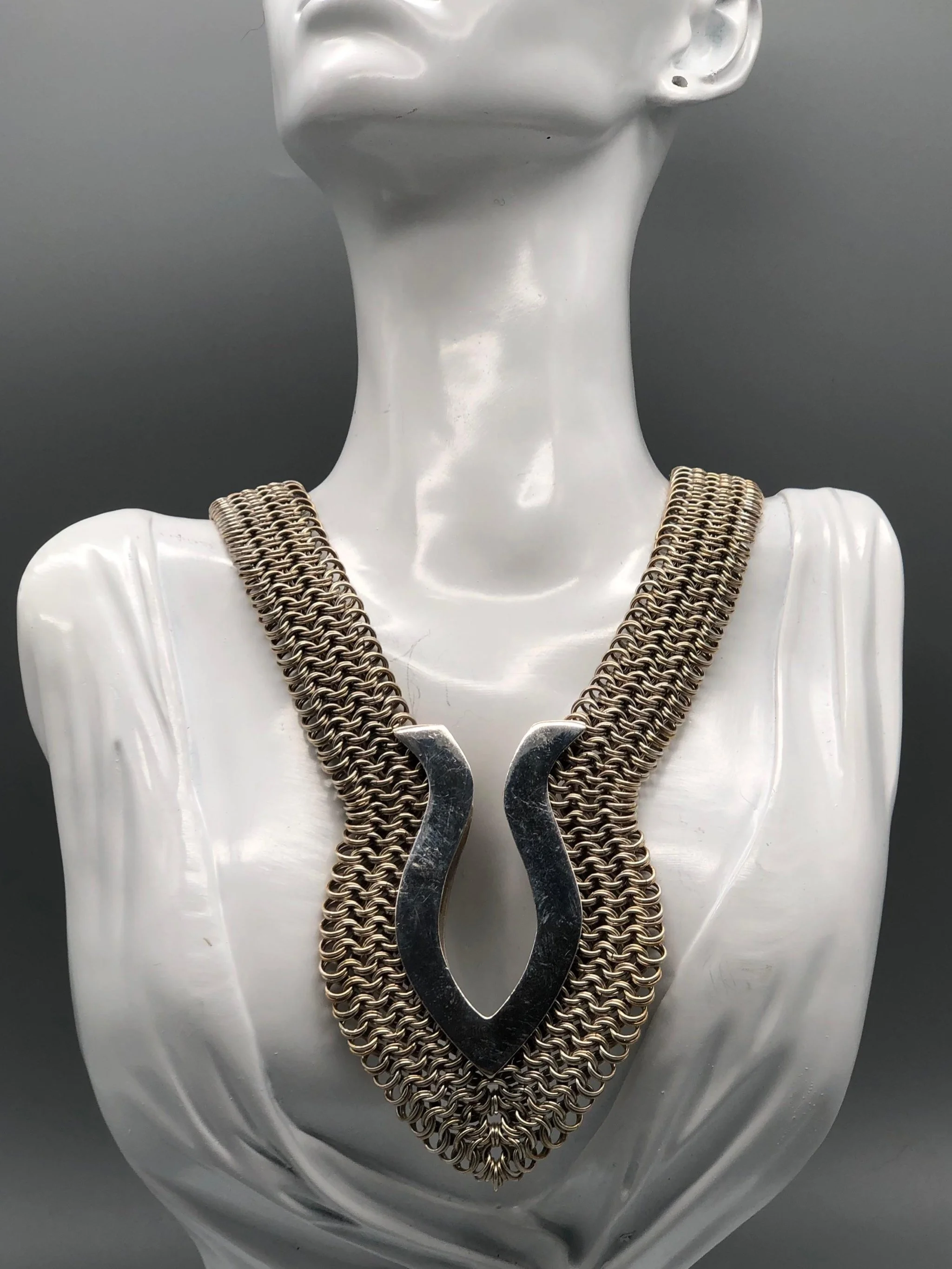 Piscis necklace by Ariadna Segafredo, crafted in woven metal mesh with a sculptural clasp for Crepundia Gioielli.