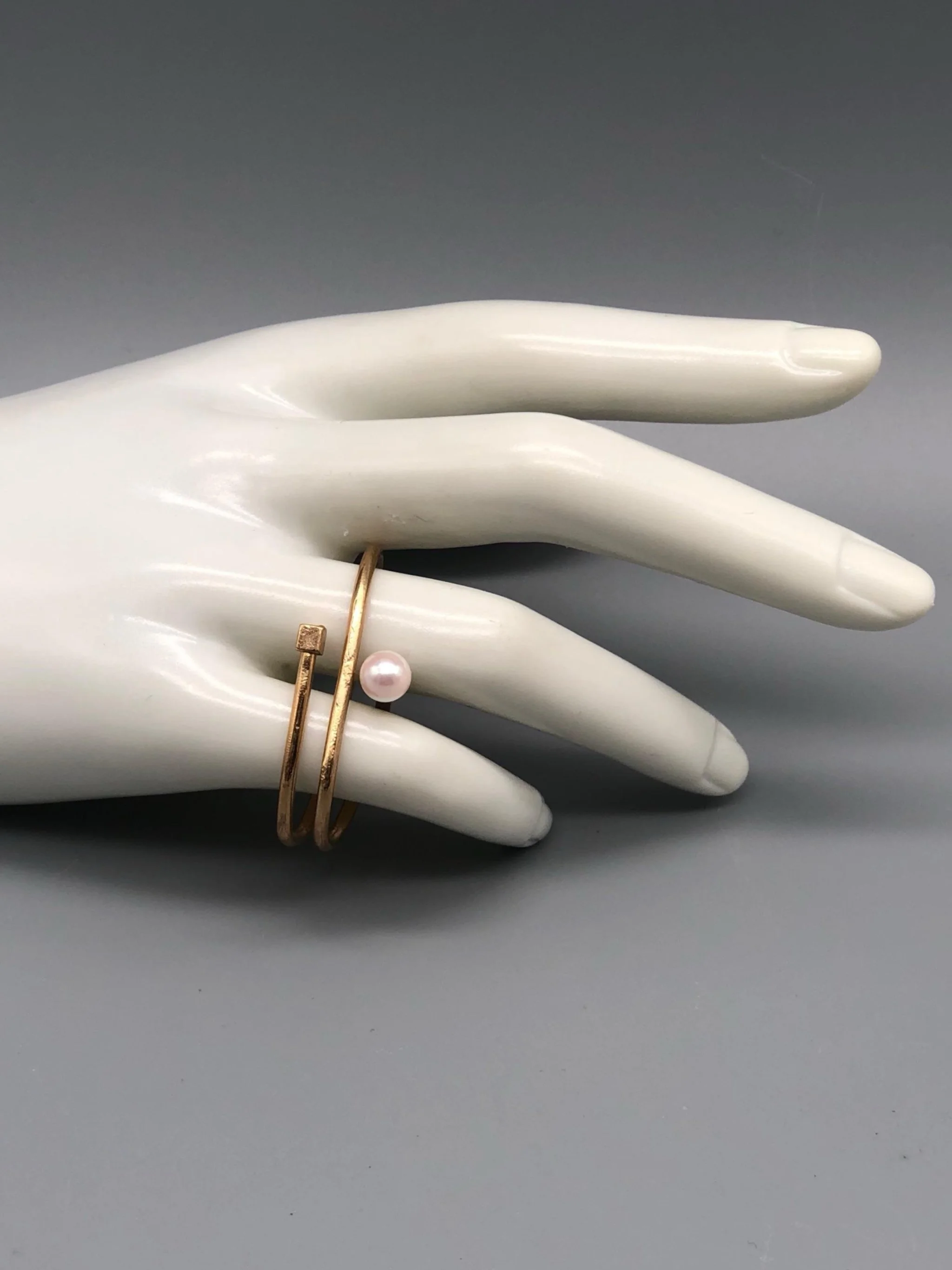Double bronze ring with Venetian glass pearl, worn across ring finger and little finger, EL Gioielli for Crepundia Gioielli Bologna