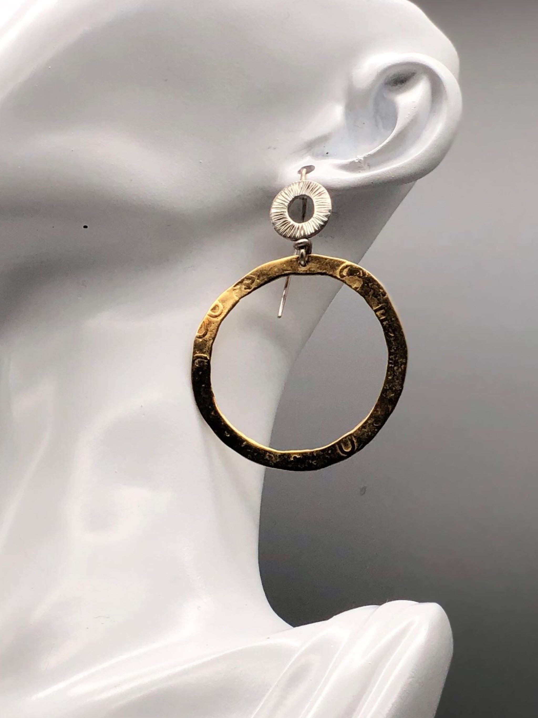 Orecchino cerchio indossato in argento e bronzo dorato design contemporaneo Gabriel Reinoso Crepundia Bologna