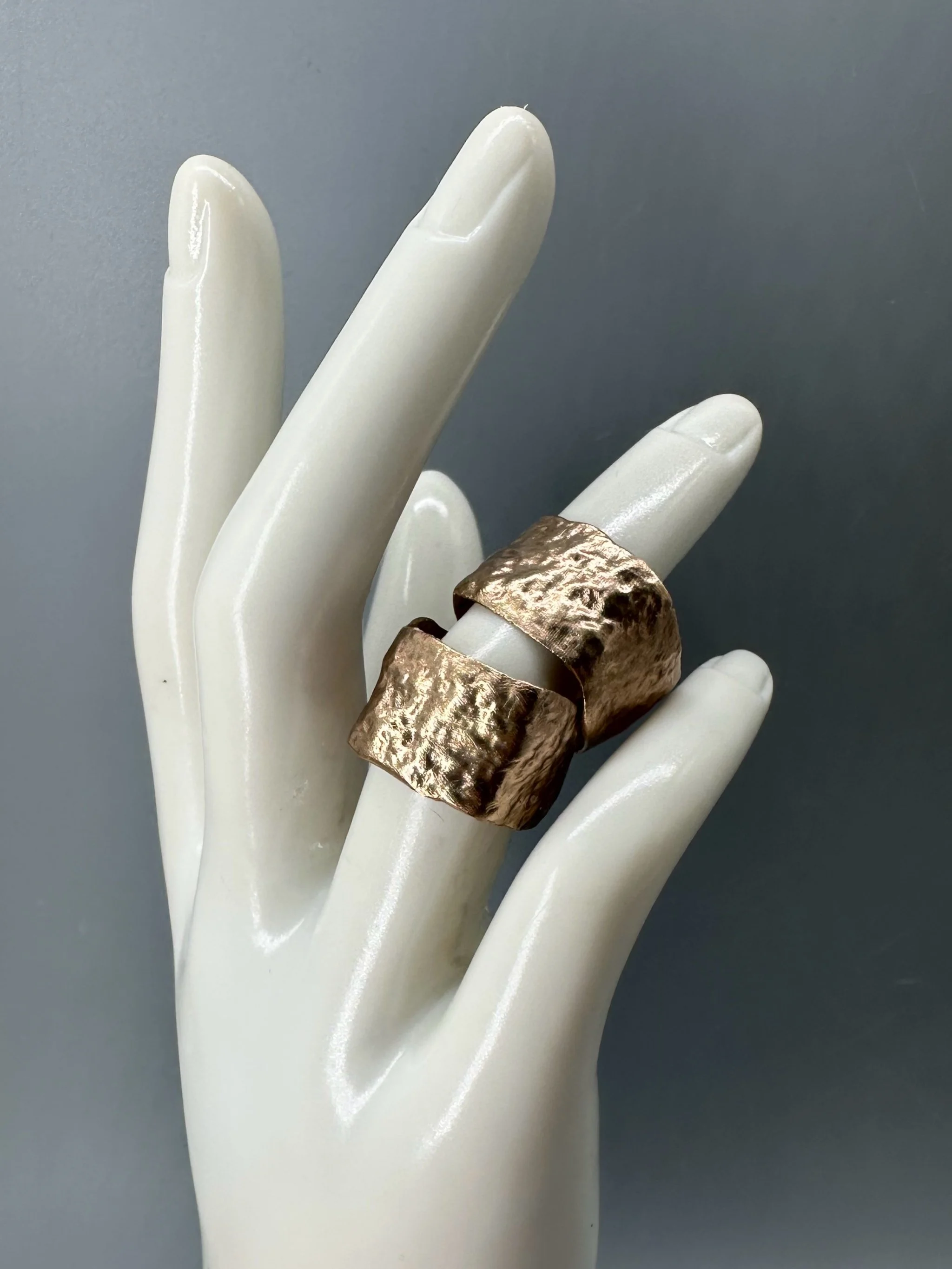 Anello Fascia Longobarda di CōDICEDS in bronzo bocciardato, dalla forma ampia e irregolare.  Longobarda wide bronze ring by CōDICEDS, with a hammered surface and irregular shape.