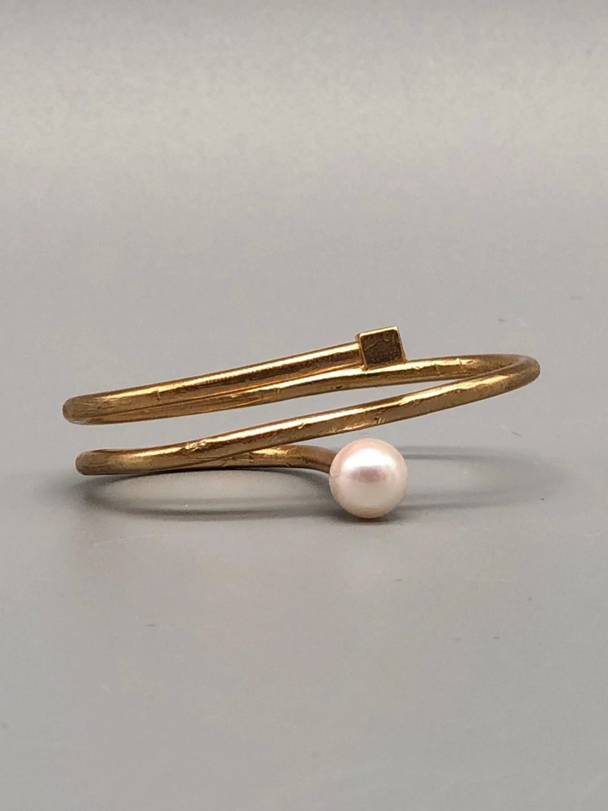Double bronze ring with Venetian glass pearl, worn across ring finger and little finger, EL Gioielli for Crepundia Gioielli Bologna