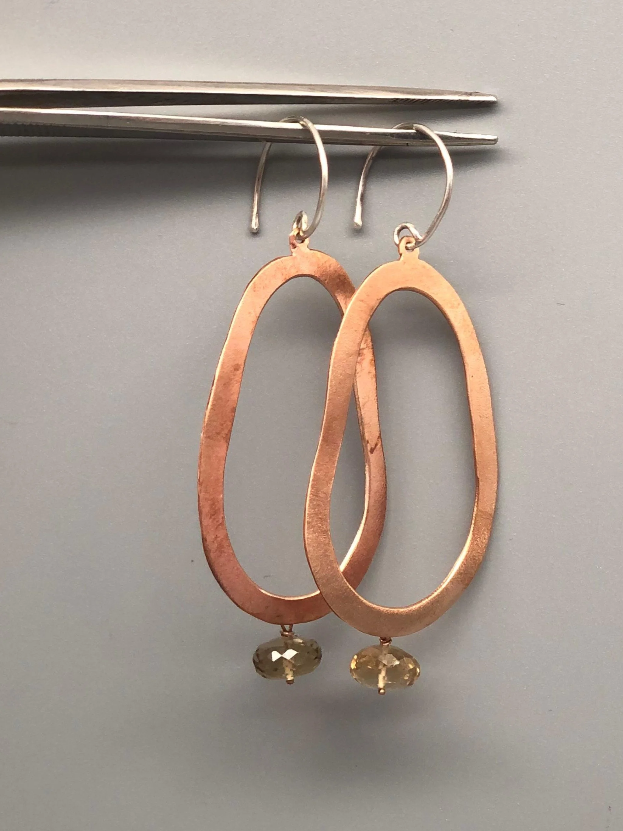 Orecchini Ellipse di Padma per Crepundia Gioielli Bologna in bronzo rosso con quarzo birra e monachelle in argento