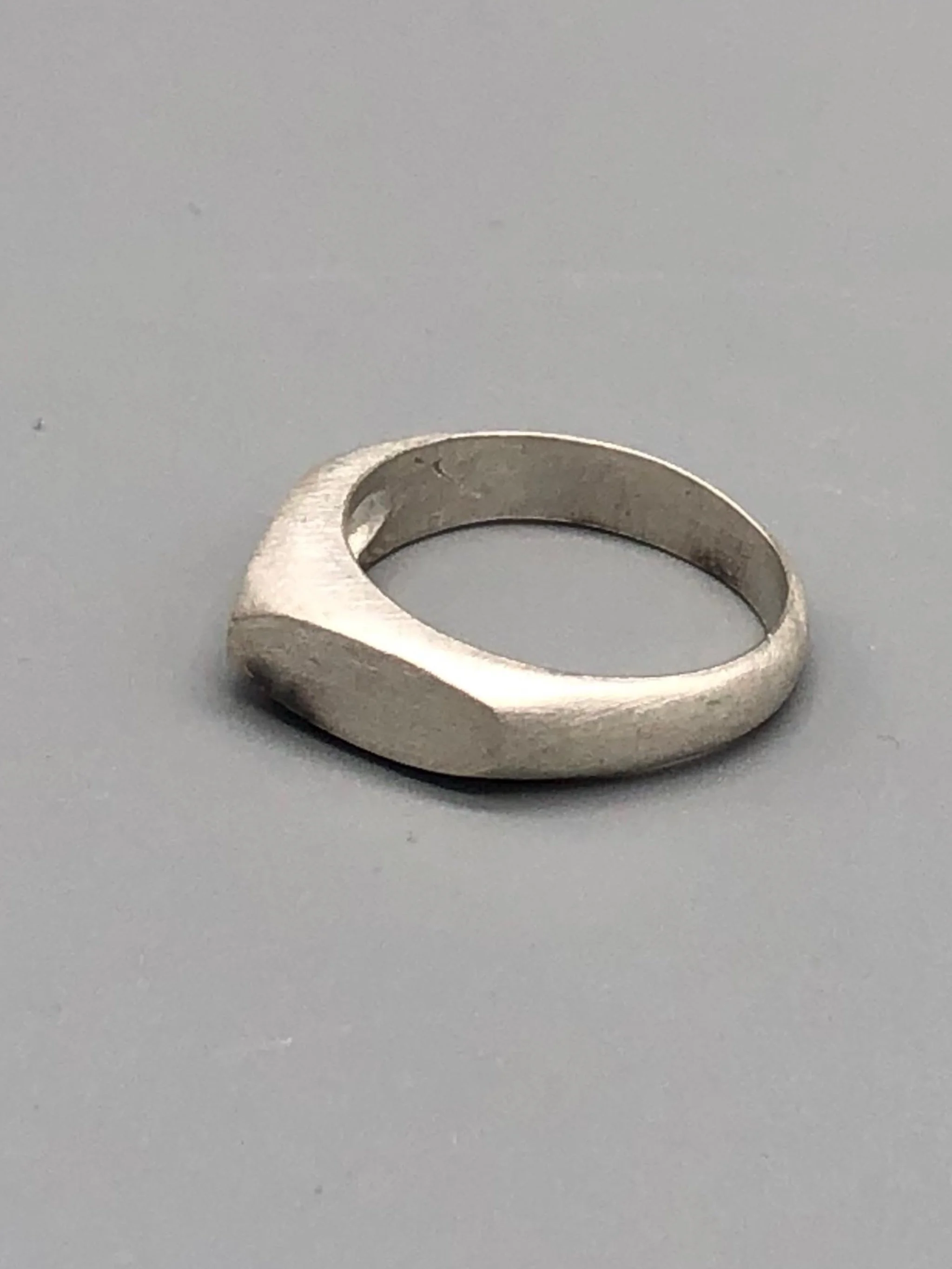 Anello Cuspide Crepundia in argento 925, con fascia geometrica, superfici sfaccettate e finitura satinata. Crepundia Cuspide ring in sterling silver 925, featuring a geometric band, faceted surface