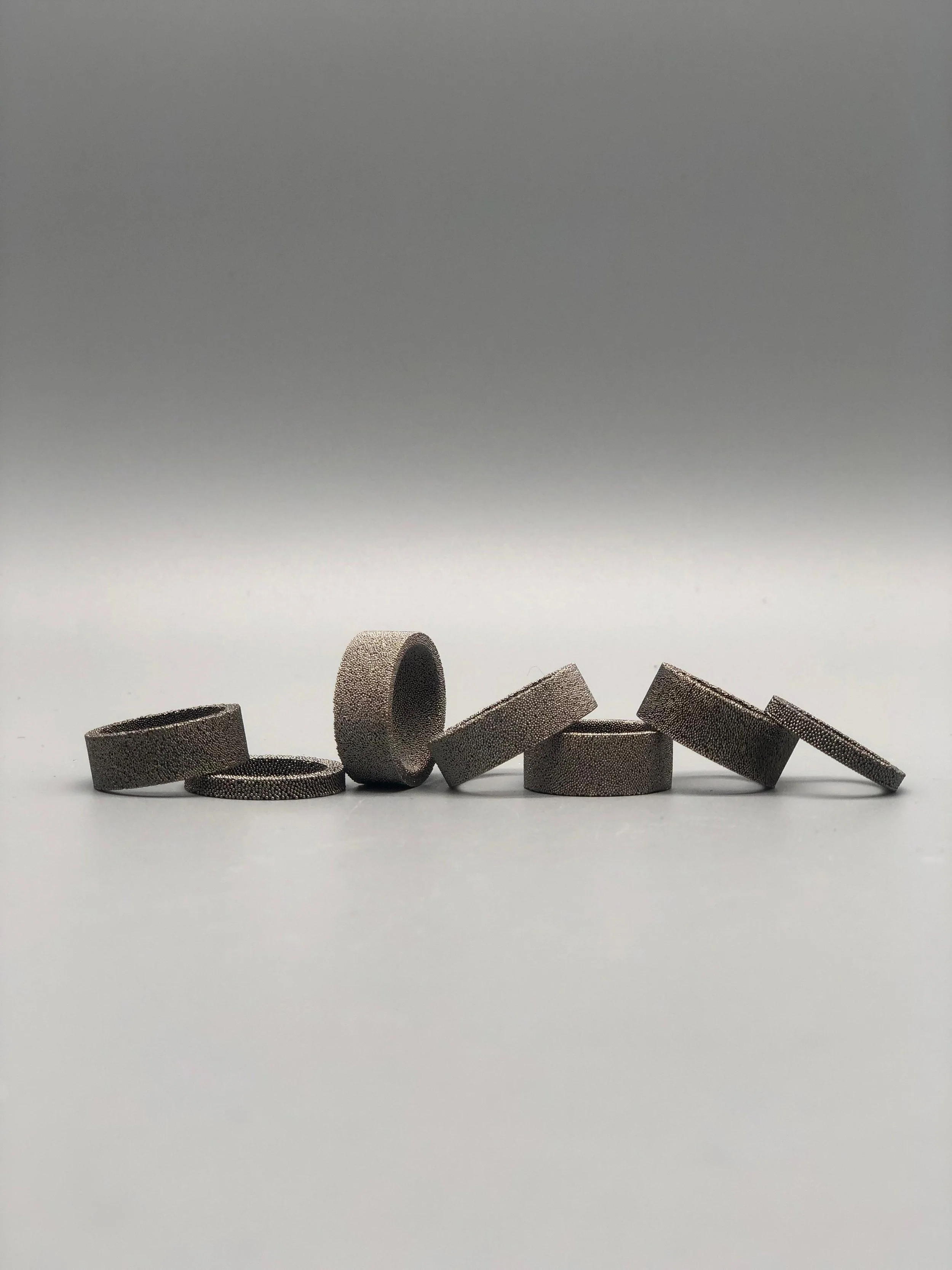 Anelli in bronzo sinterizzato da recupero industriale, superficie granulosa e materica, relazione tra pieni e vuoti — Francesca Valpiani, Crepundia Gioielli — Crepundia Bologna
Rings in sintered bronze from industrial recovery, granular textured surf