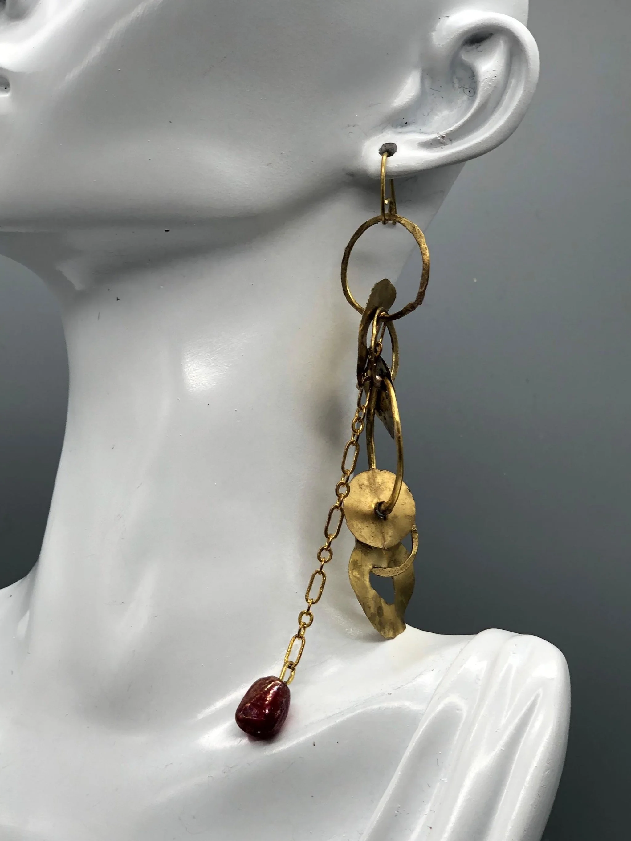 Mono orecchino Orbit Chain di Claudia Cuzzeri in ottone opaco con elementi circolari irregolari, catena e dettaglio in vetro di Murano