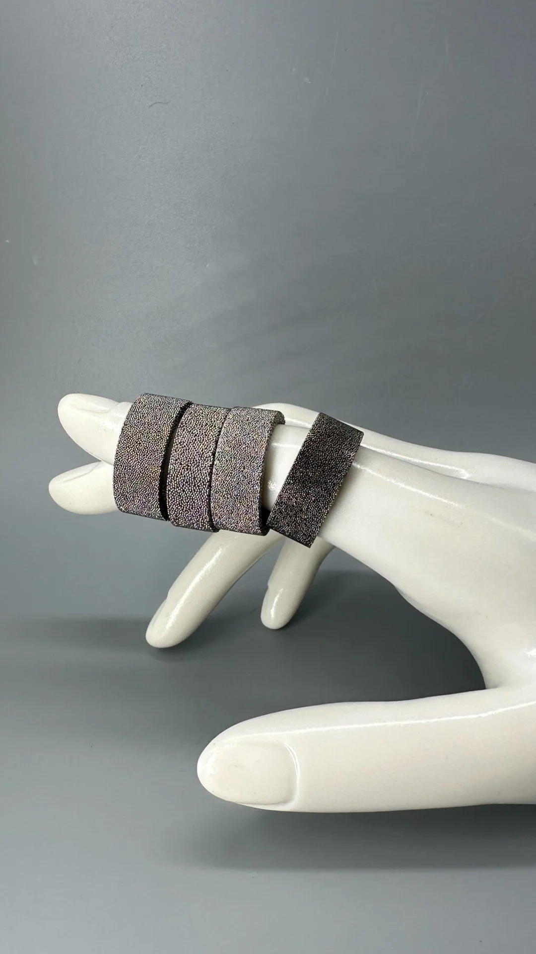 Anelli Materia di Francesca Valpiani in bronzo sinterizzato, finiture oro giallo, rosa, argento e rutenio. Francesca Valpiani Materia rings in sintered bronze, with yellow gold, rose gold, silver and