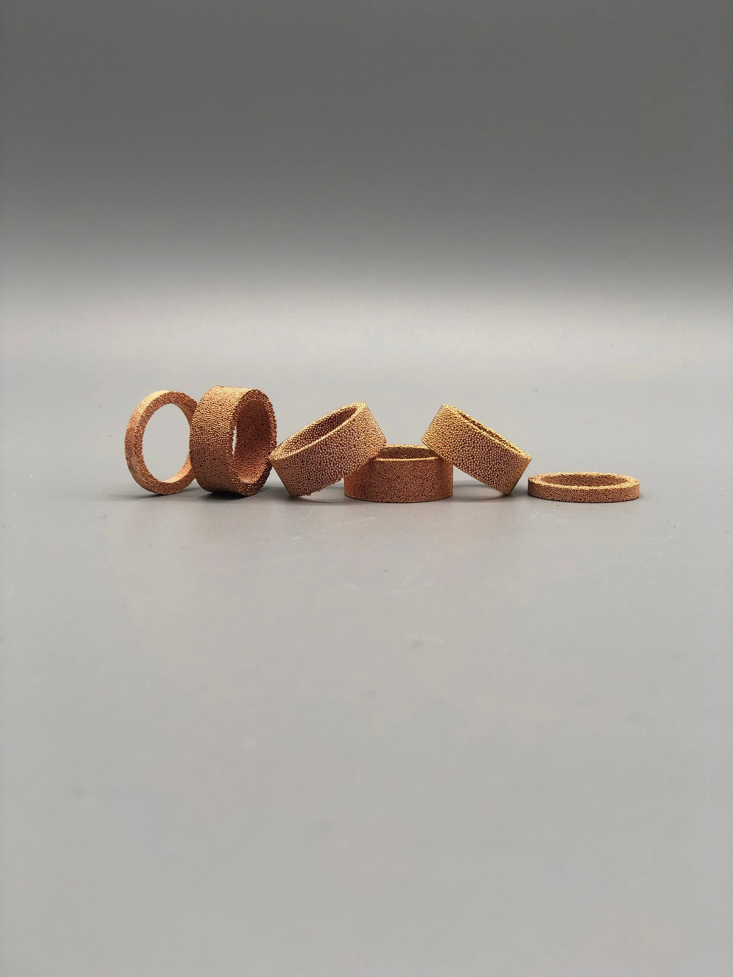 Anelli in bronzo sinterizzato da recupero industriale, superficie granulosa e materica, relazione tra pieni e vuoti — Francesca Valpiani, Crepundia Gioielli — Crepundia Bologna
Rings in sintered bronze from industrial recovery, granular textured surf