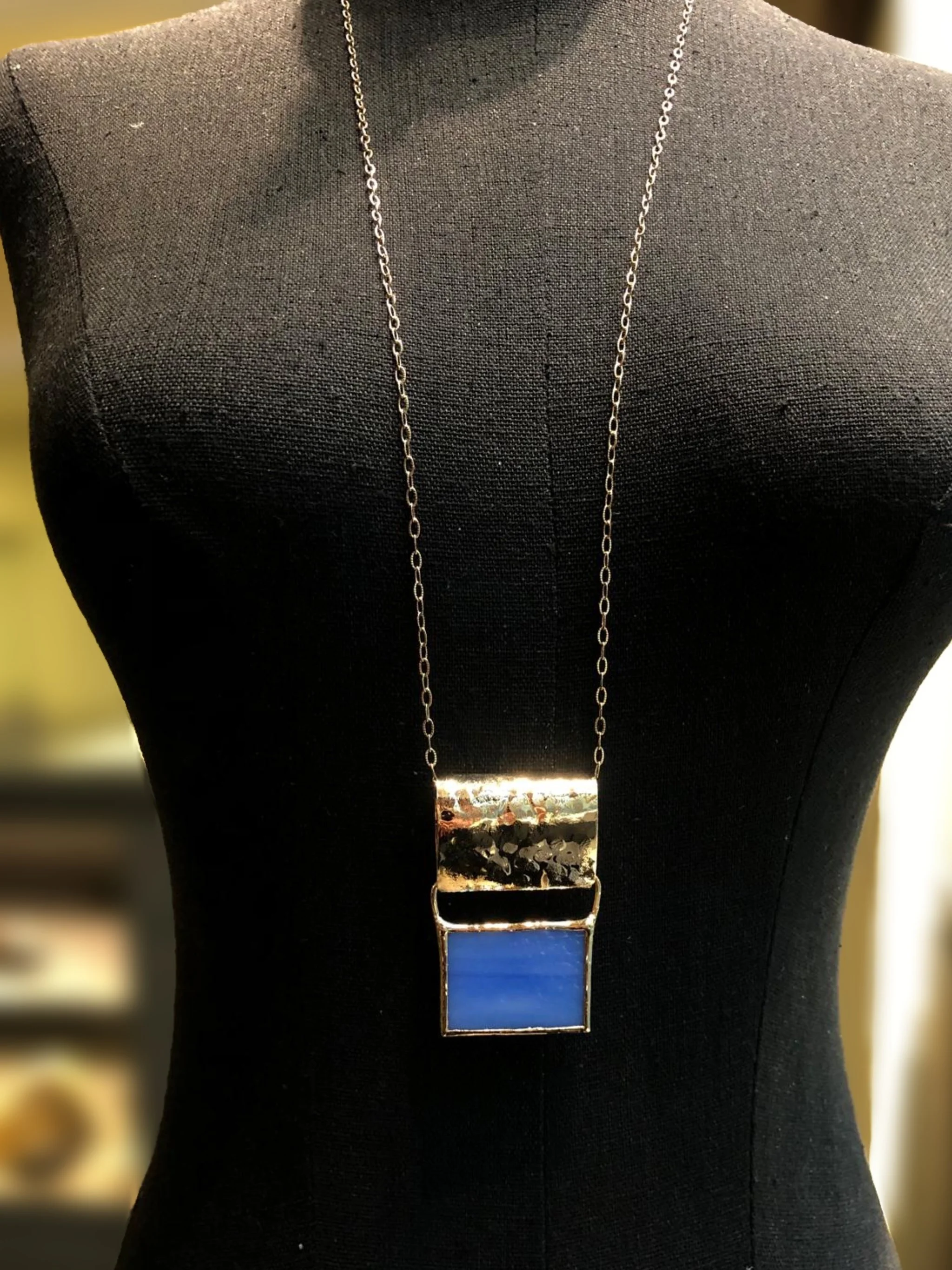 Collana ‘70 Azzurra di Anni Luce, ottone dorato e vetro di Murano. ‘70 Azzurra necklace by Anni Luce, gold-plated brass and Murano glass.