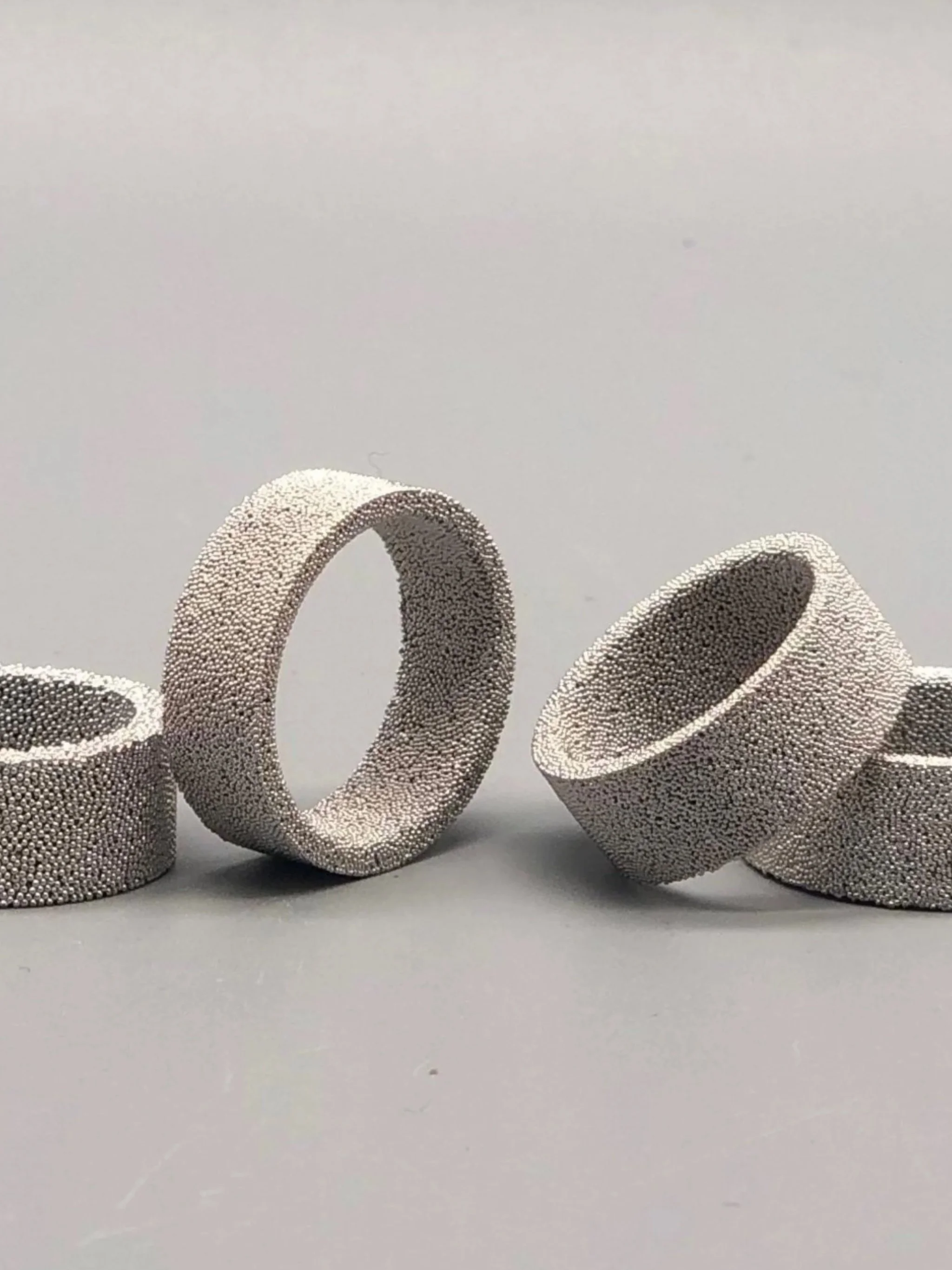 Anelli Materia di Francesca Valpiani in bronzo sinterizzato, finiture oro giallo, rosa, argento e rutenio. Francesca Valpiani Materia rings in sintered bronze, with yellow gold, rose gold, silver and