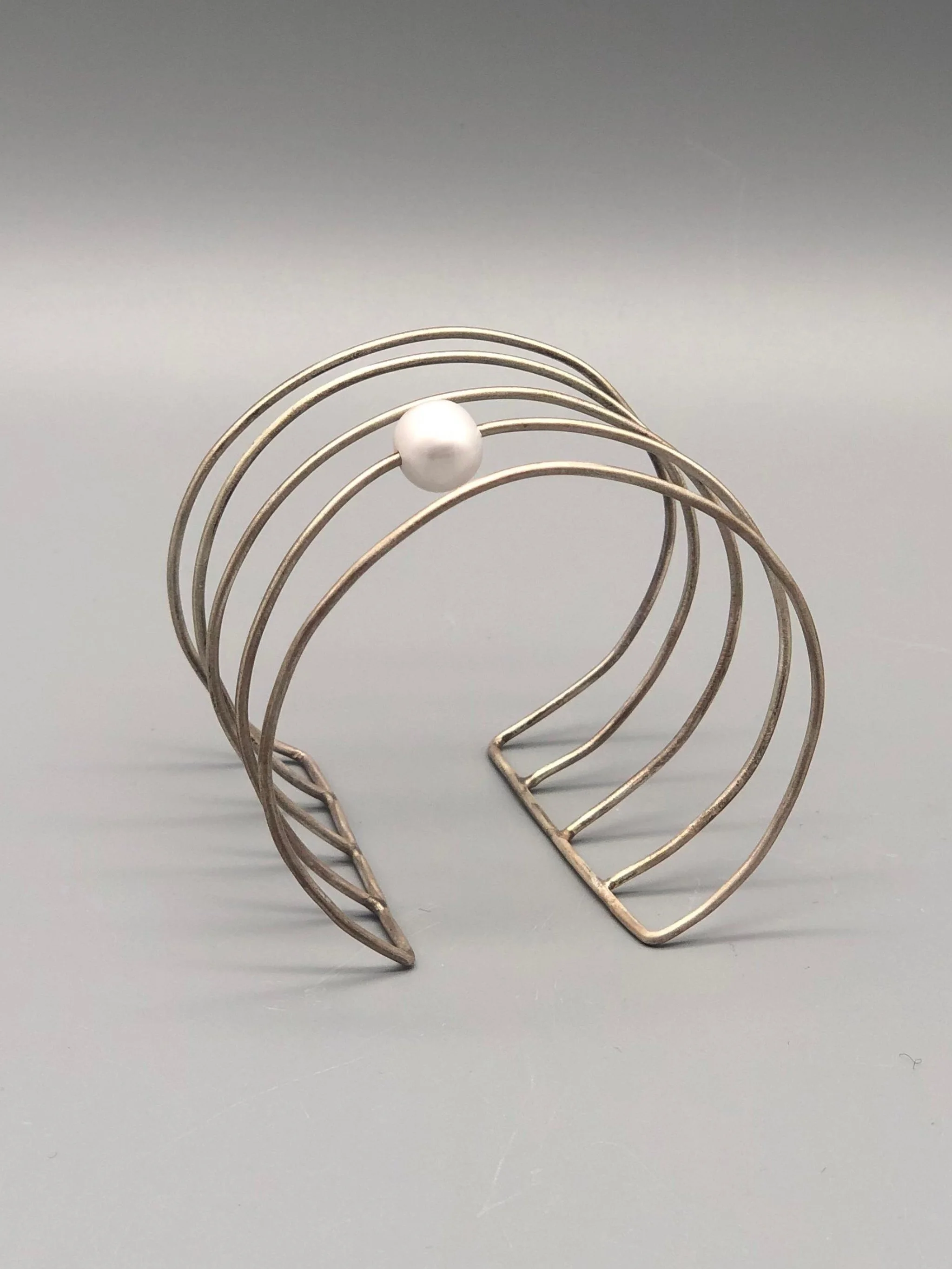 Bracciale Asmara in argento 925 con perla bianca, design scultoreo a linee aperte — Crepundia Gioielli — Crepundia Bologna, architectural silver cuff bracelet with pearl