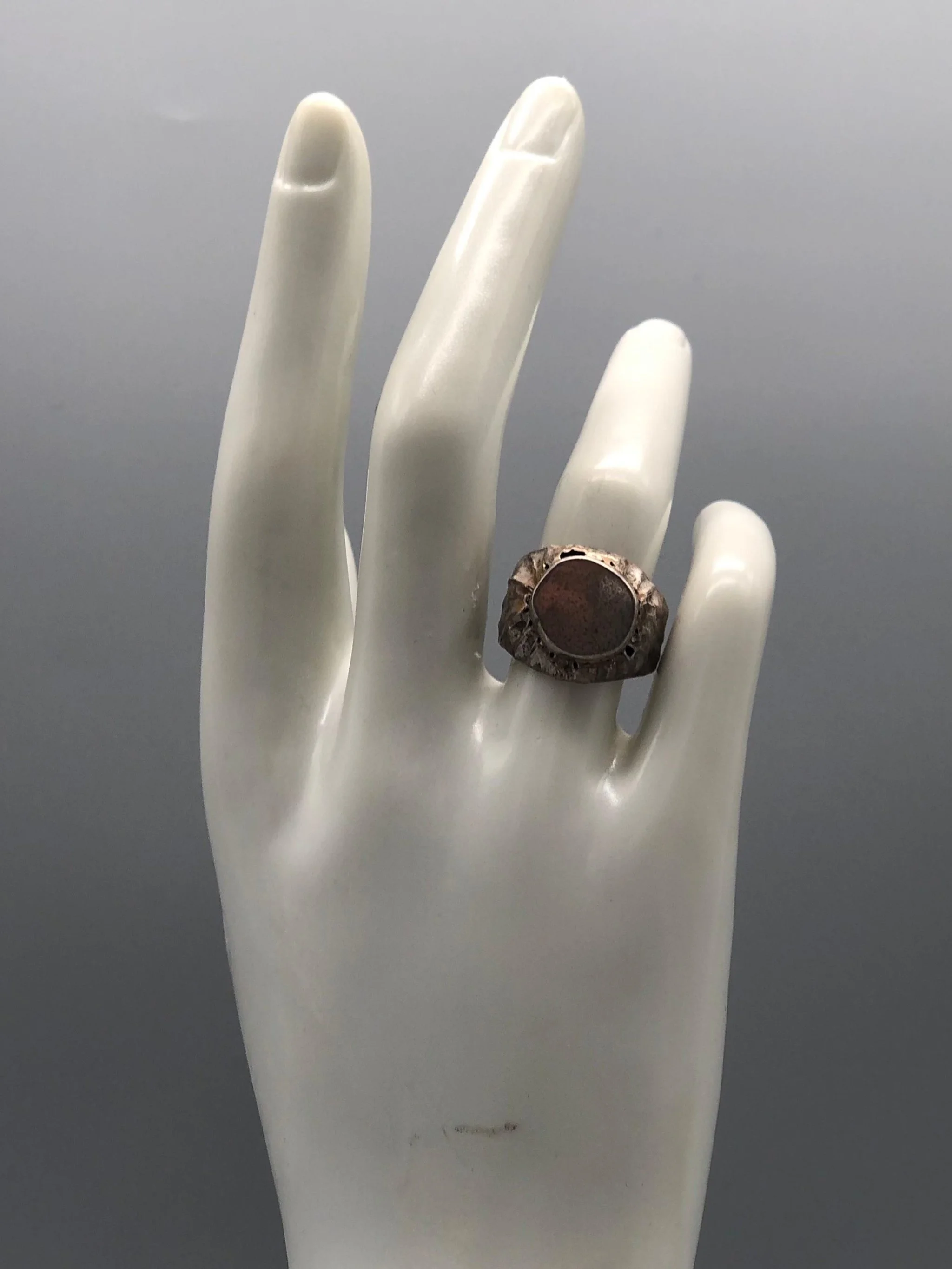 Marco Mangàni signet ring in sterling silver with irregular sculptural surface and flat central plate, Crepundia Gioielli Bologna