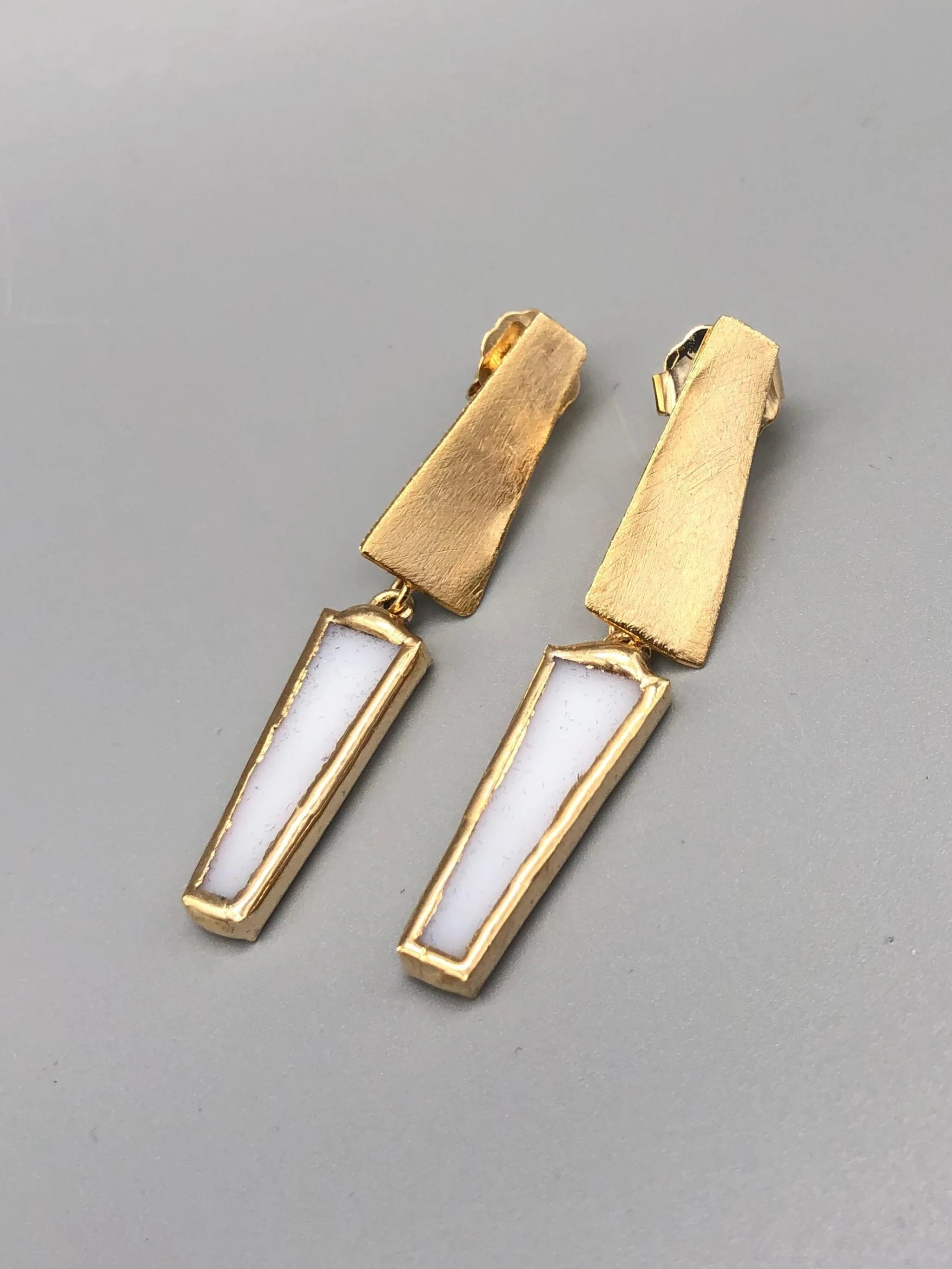 Trapezio Bianco earrings by Anni Luce, featuring geometric gold-plated brass elements and white Murano glass.