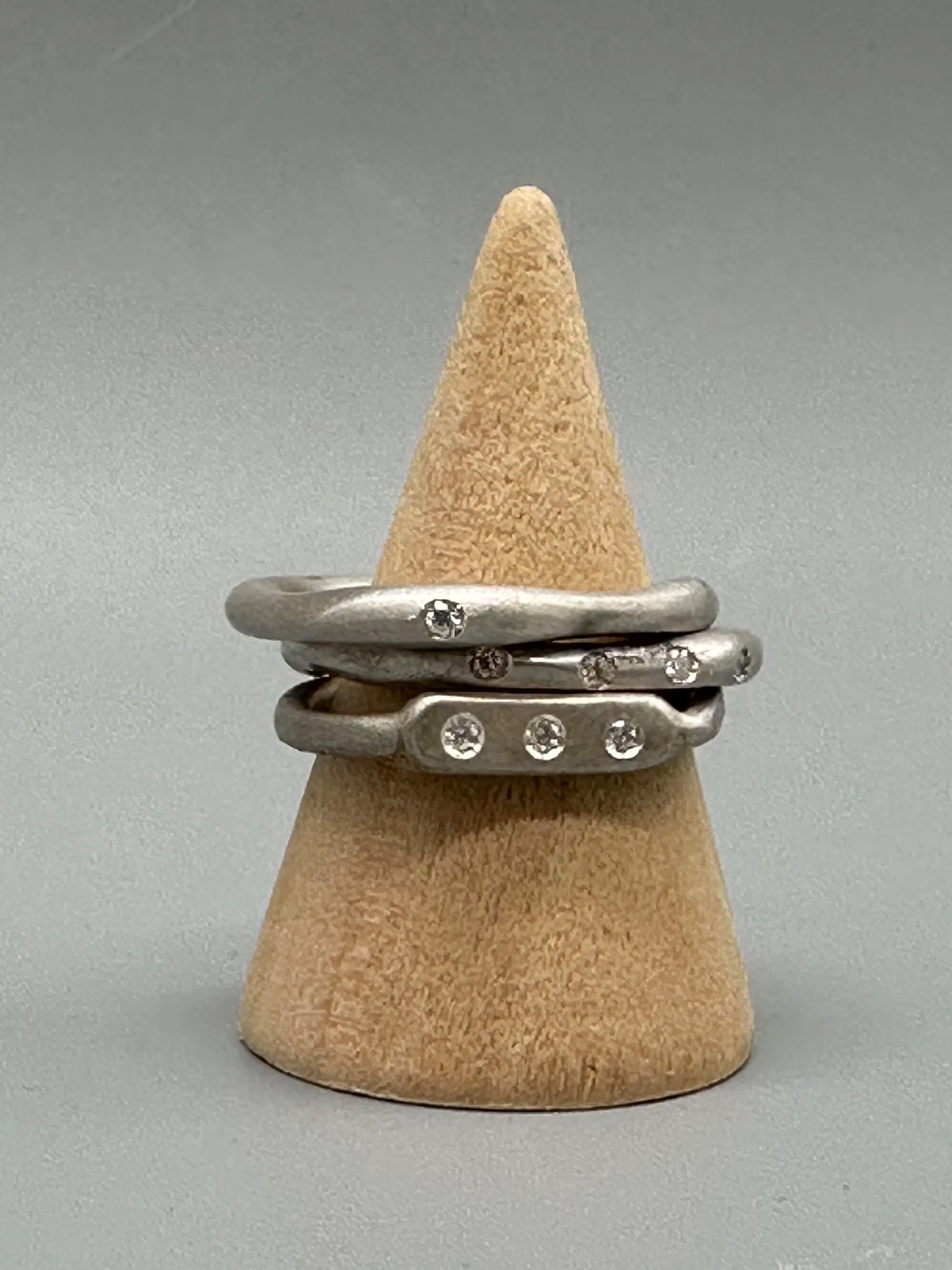 Interplay di Crepundia Gioielli, composizione di tre anelli in argento Full Wave, Wave e Flat 3, con diamanti per un totale di 0,12 ct. Interplay by Crepundia Gioielli, a set of three contemporary sil
