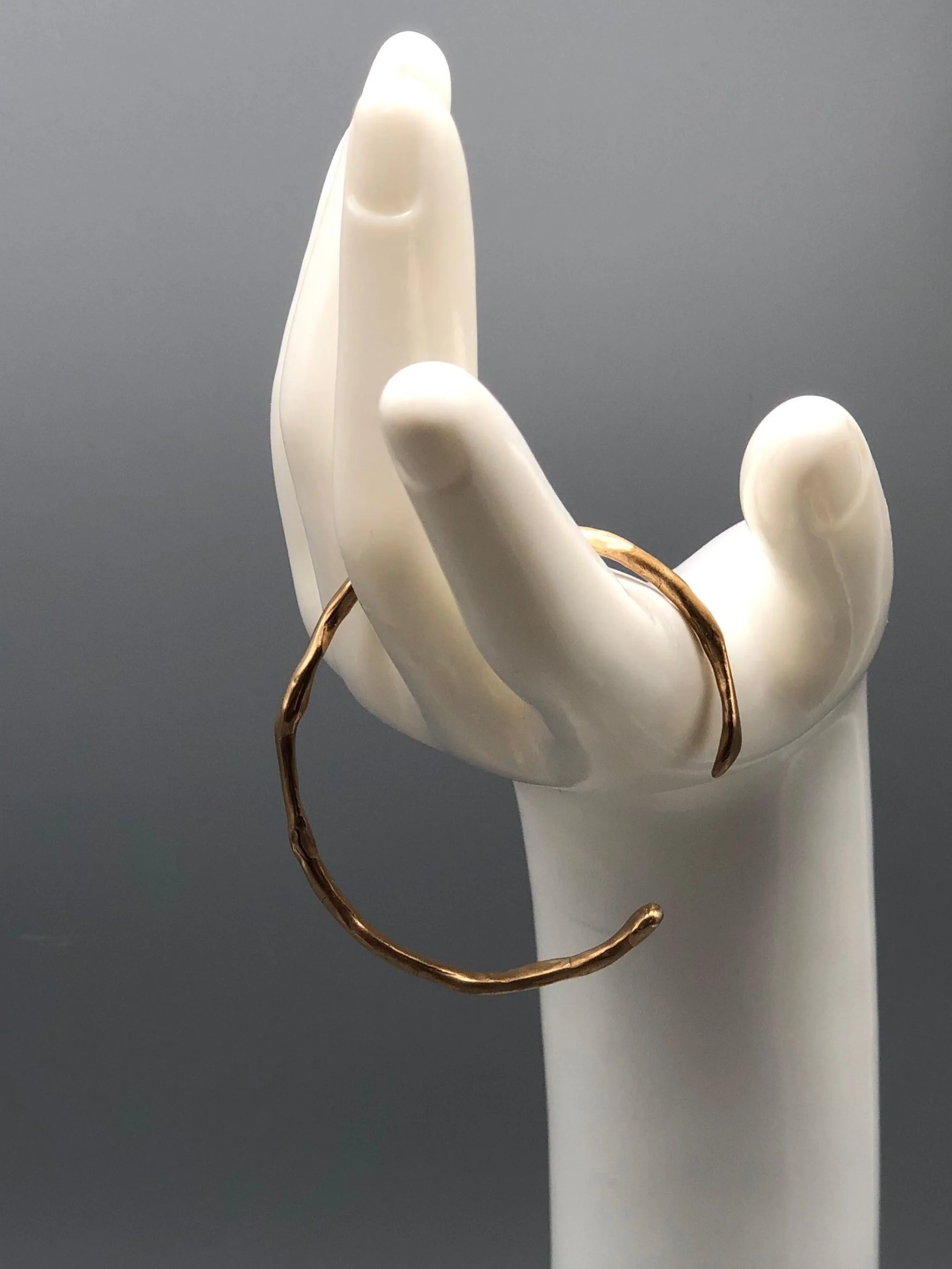 Handmade slender bronze cuff bracelet with organic sculptural shape by Floret Gioielli.