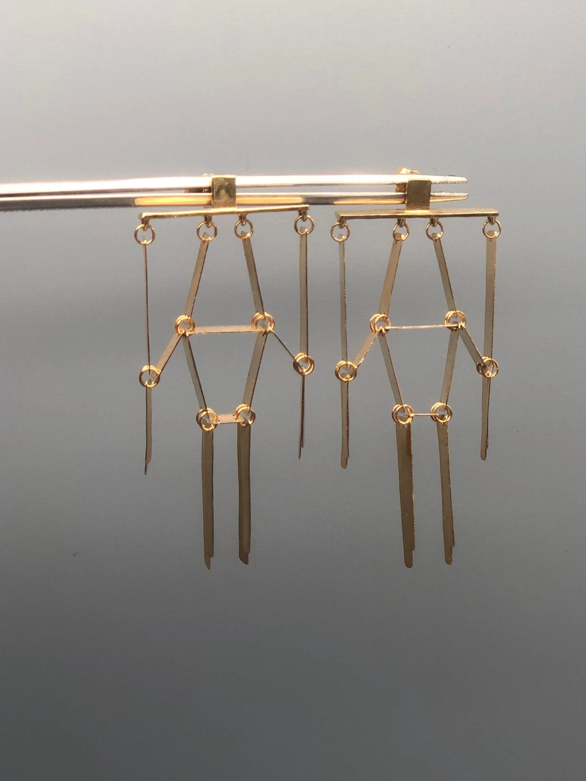 Elisa Deval Alo Medi earrings in sterling silver with 18 karat yellow gold plating, geometric contemporary dangling earrings worn on mannequin, Crepundia Gioielli Bologna