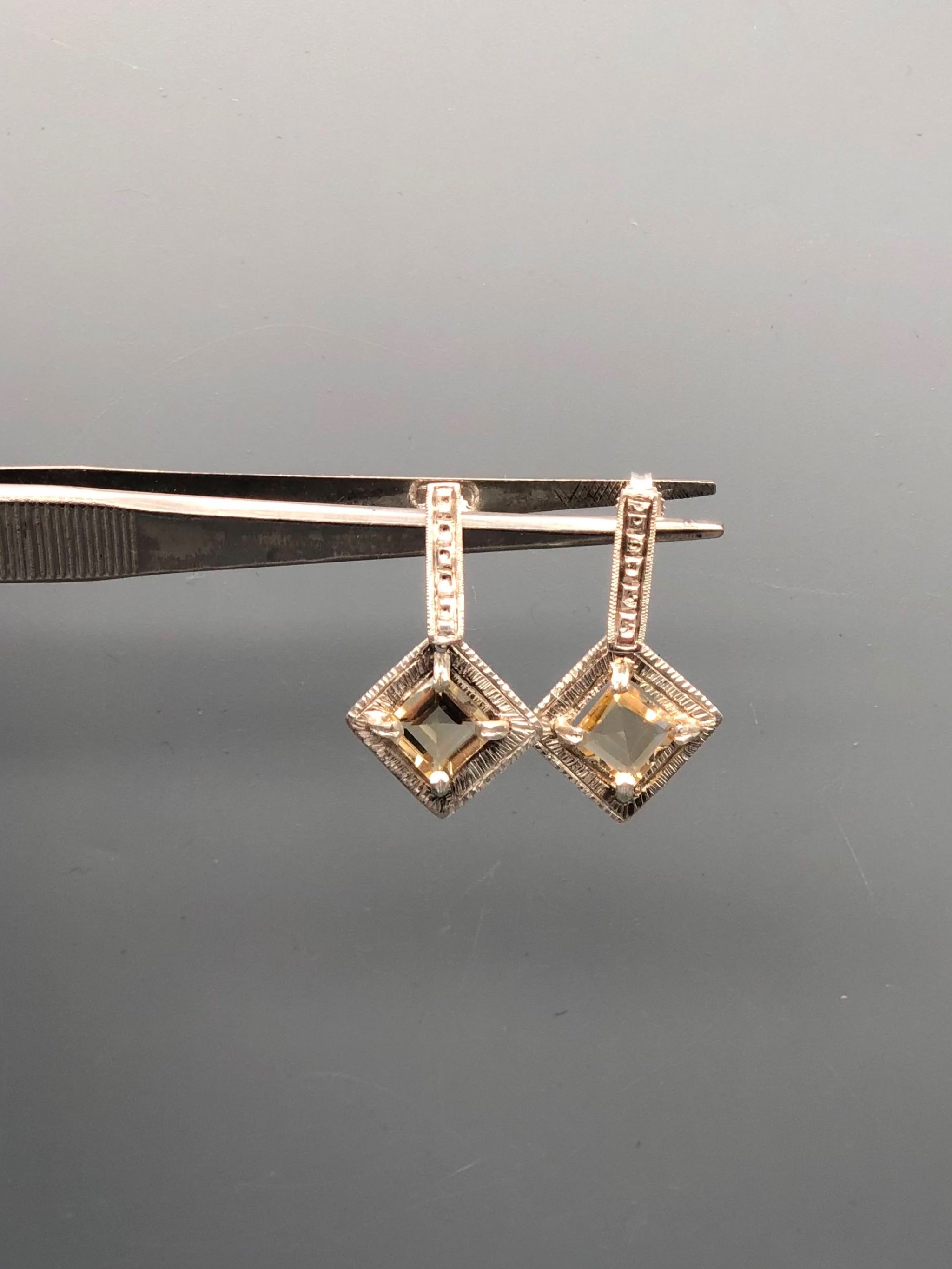 Orecchini Vedado in argento lavorato e quarzo citrino sfaccettato, con pietra montata a rombo. Vedado earrings in textured silver and faceted citrine quartz, with a diamond-shaped setting.