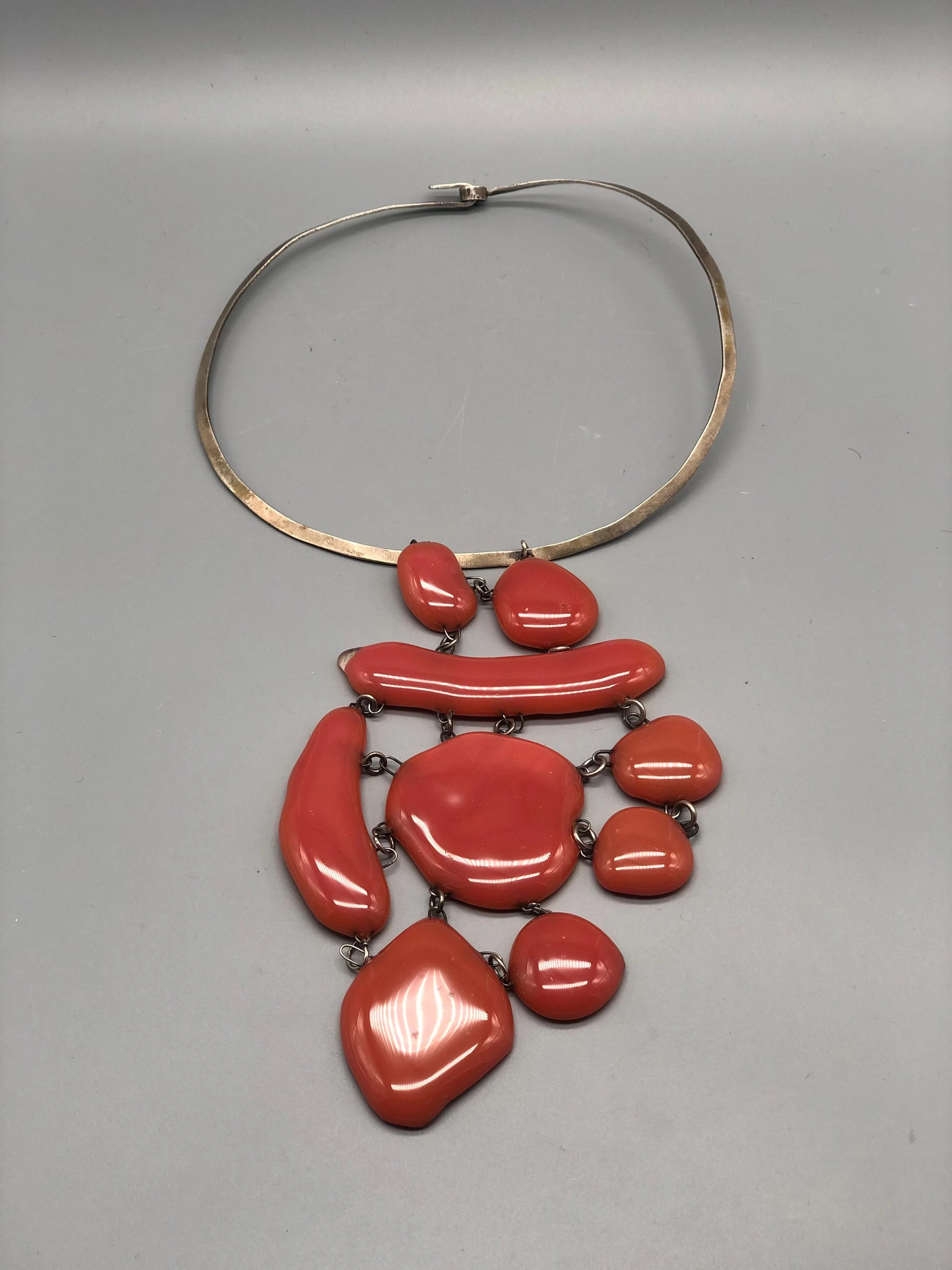 Manumara Arte Design — statement necklace in red fused glass with sculptural composition and contemporary lines, available at Crepundia Gioielli Bologna.