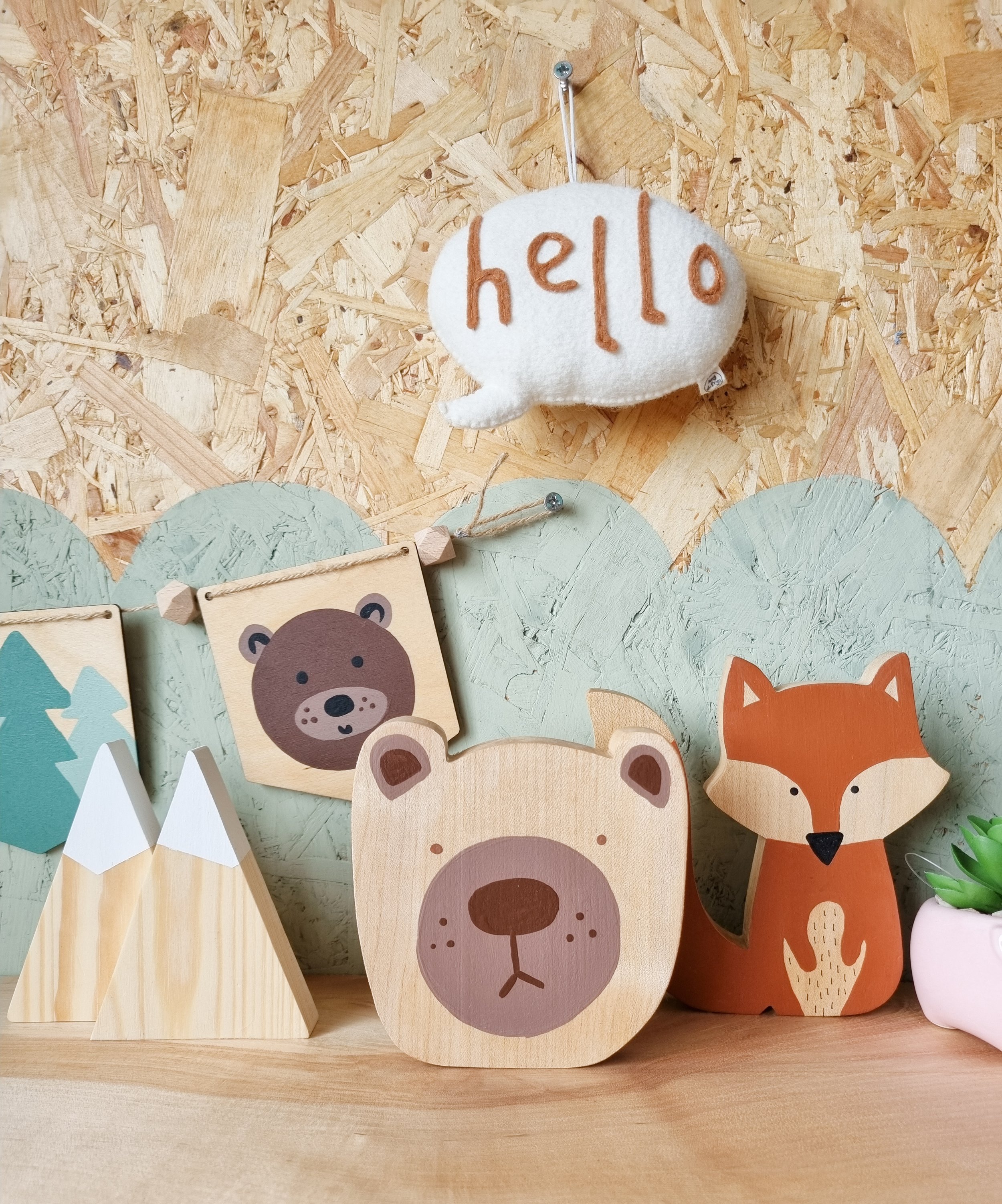 Handmade wooden bear decoration on display with other hand painted wooden decor items.