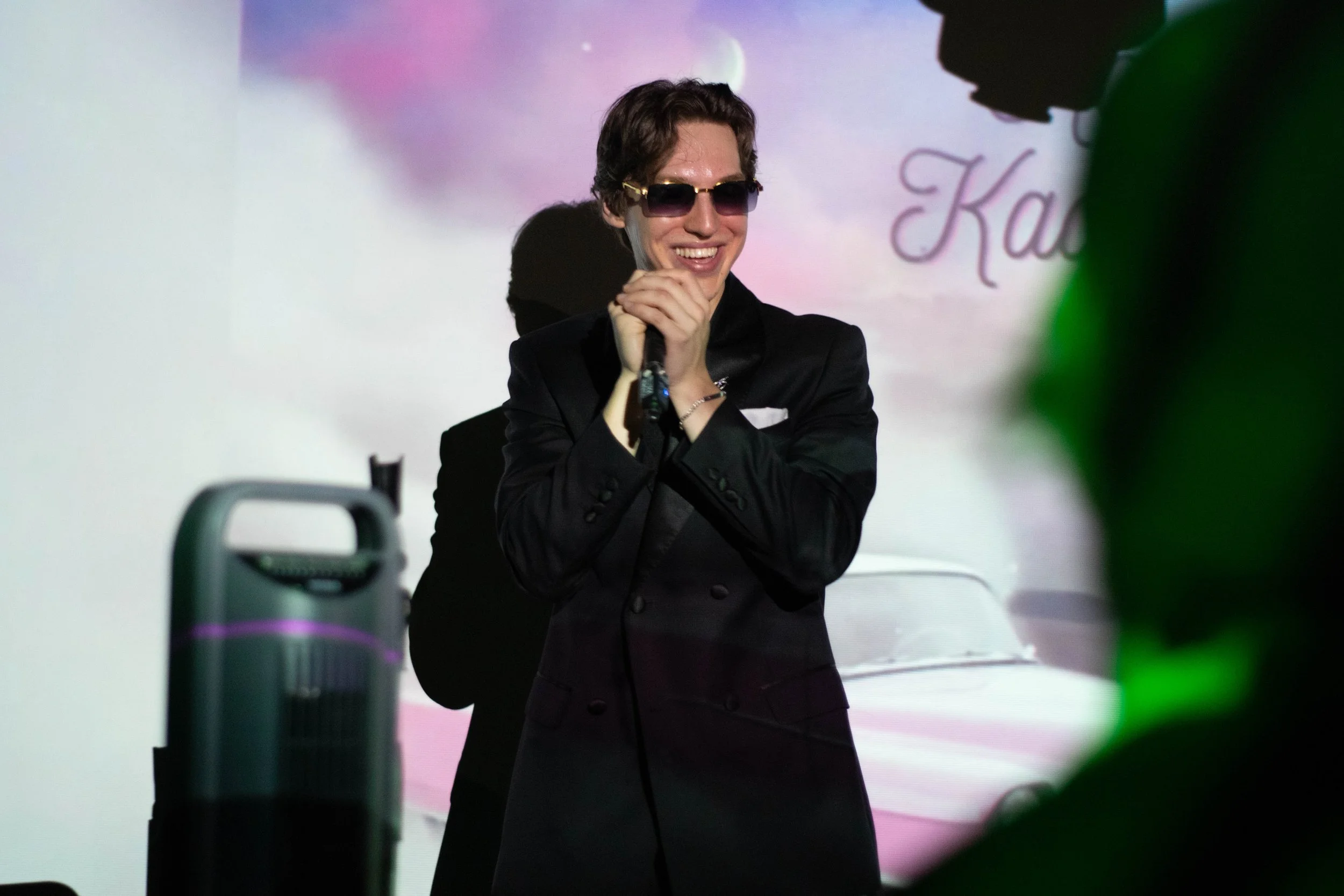 8ond black blazer from crowd smiling kati kadillac projection.jpg