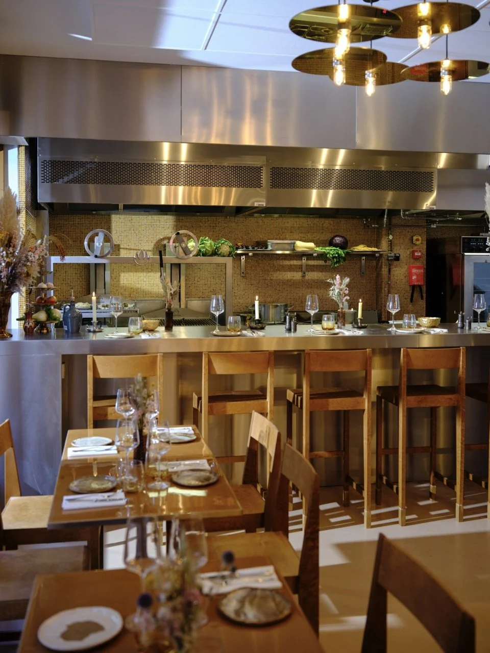 Salle à manger de Jolia, disponible pour des grandes tablées et privatisations à Paris 11ème, dans le haut Marais. Cuisine ouverte sur la salle