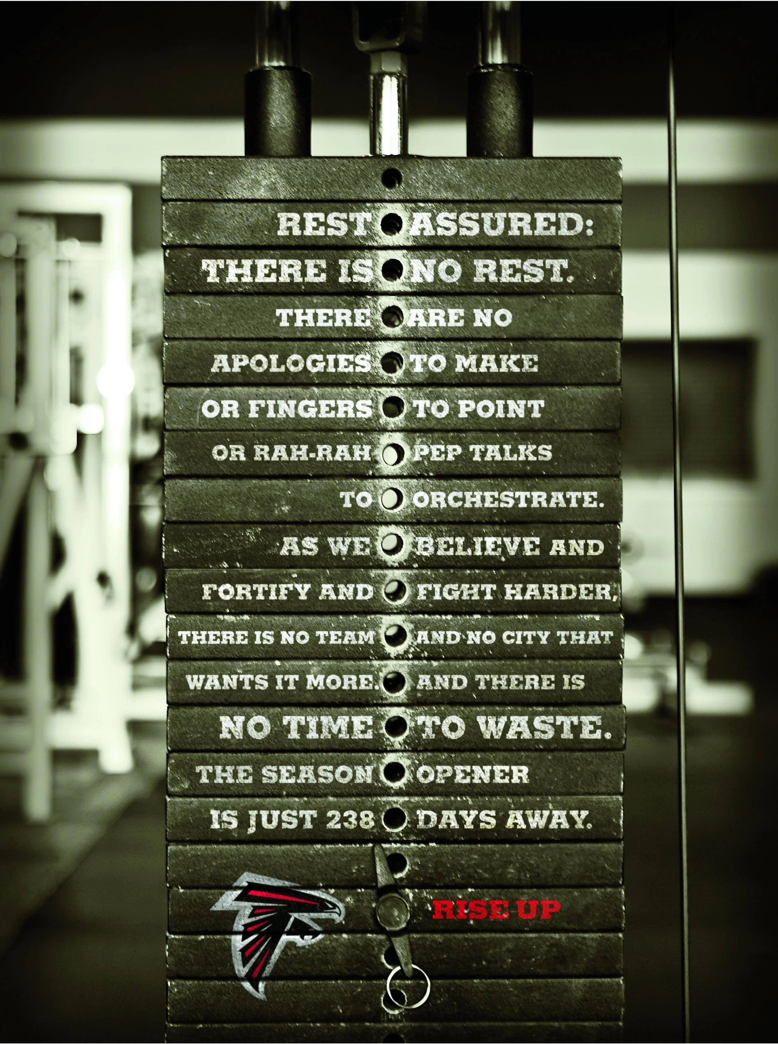 Atlanta Falcons newspaper ad featuring a stack of weights in a weight room with a headline that reads, "Rest assured: there is no rest."