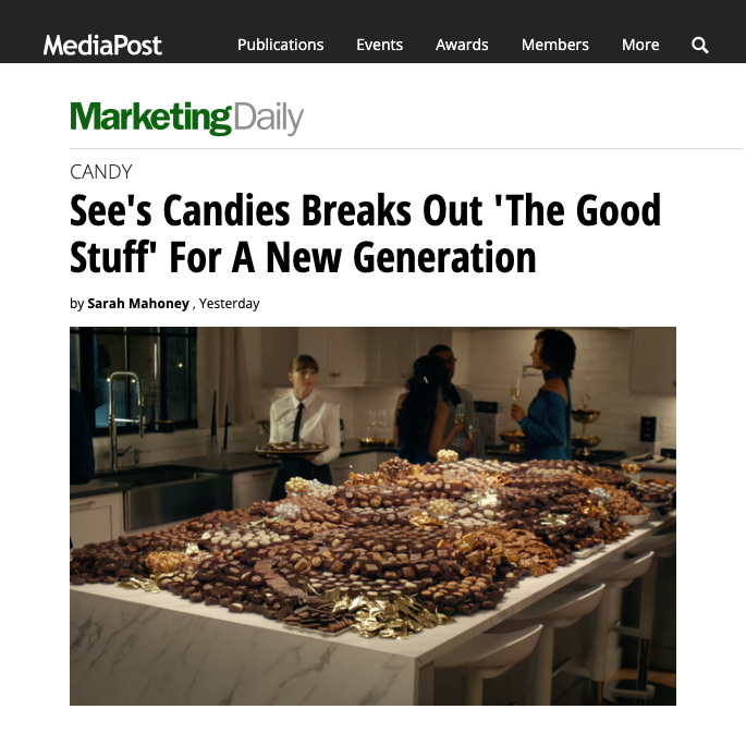 A table filled with various chocolates and candies in a modern kitchen setting, with people in the background at a social gathering.
