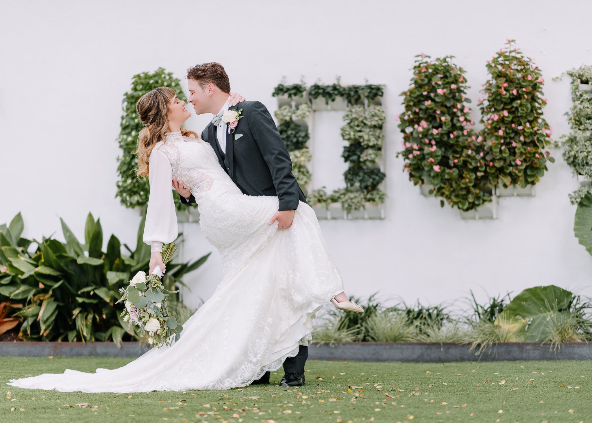 Wedding Couples at Hummingbird House doing a dip infant of a love sign 