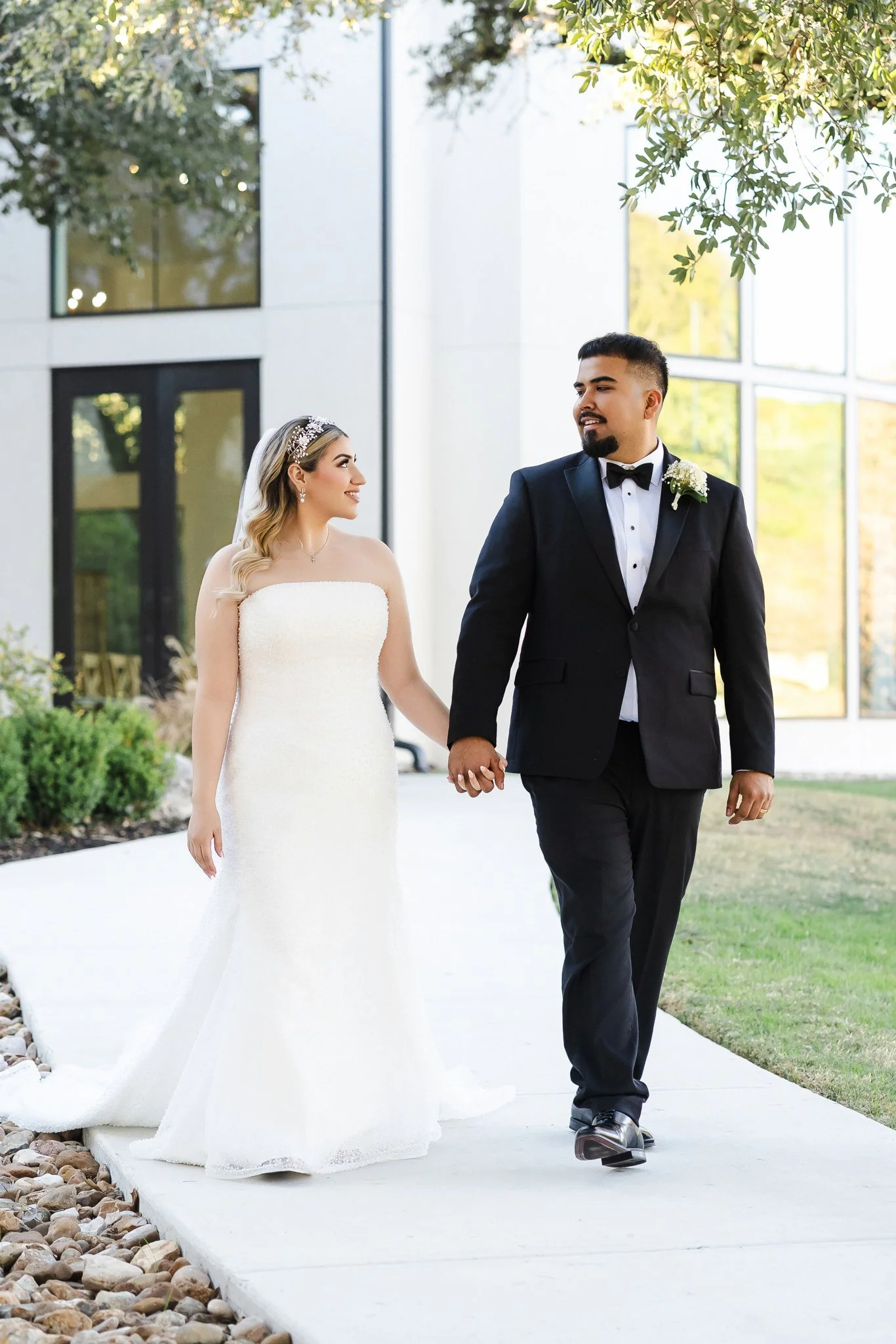 Bride and groom walking hand in hand at a modern outdoor wedding venue, photographed by an Austin wedding photographer, PhotosbyMkay