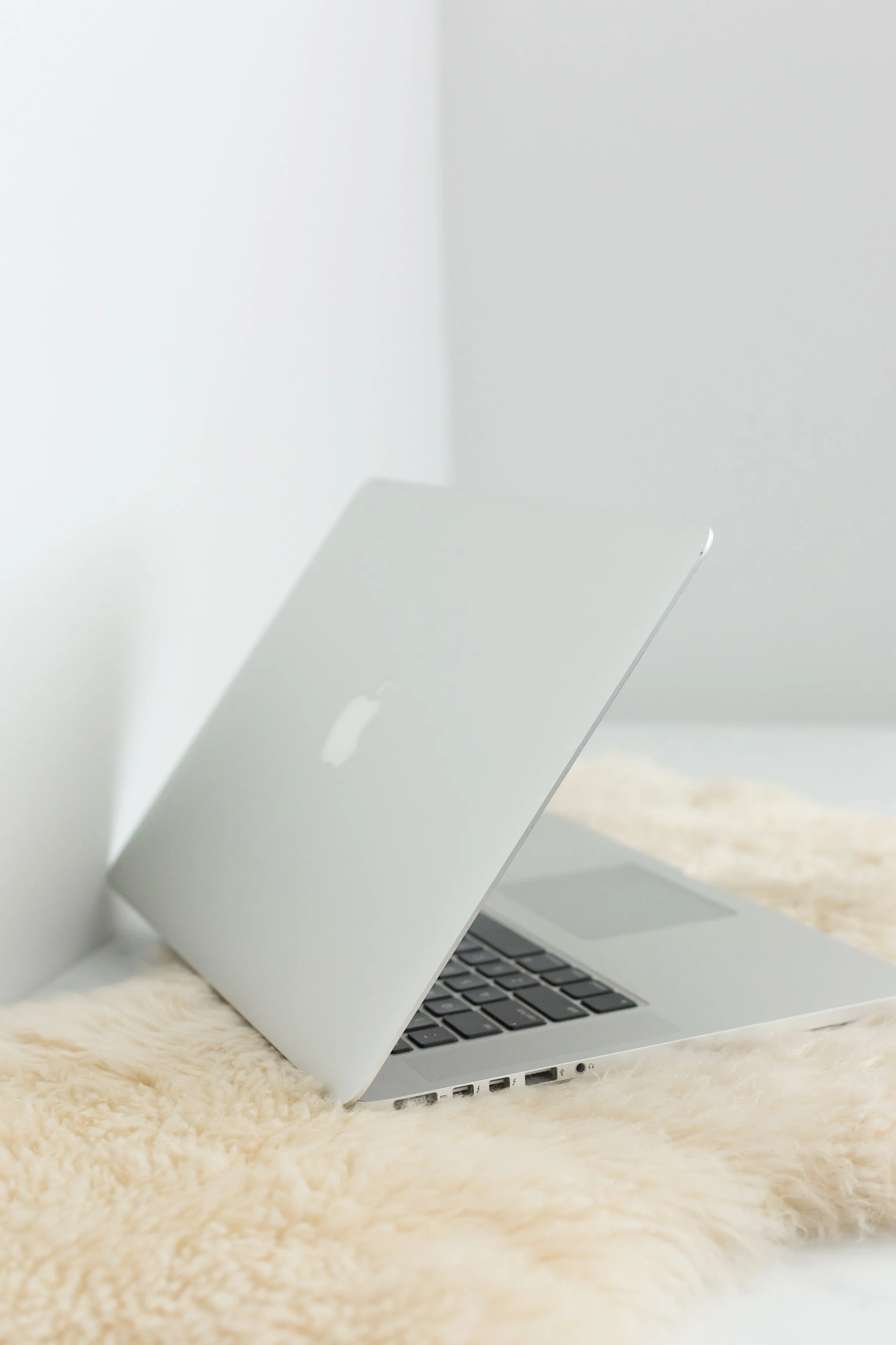 macbook open on fuzzy rug