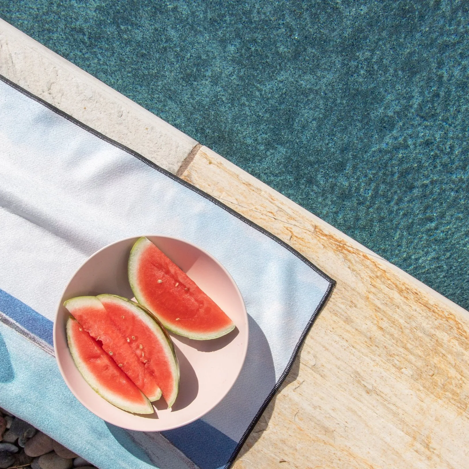 a bowl of watermelon by the pool
